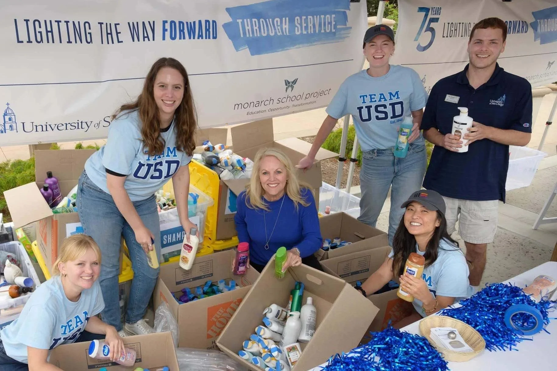university of san diego volunteers and mission edge csr team sorting toiletry donations for the monarch school project