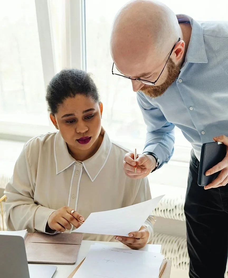 man and woman reviewing paperwork together in office