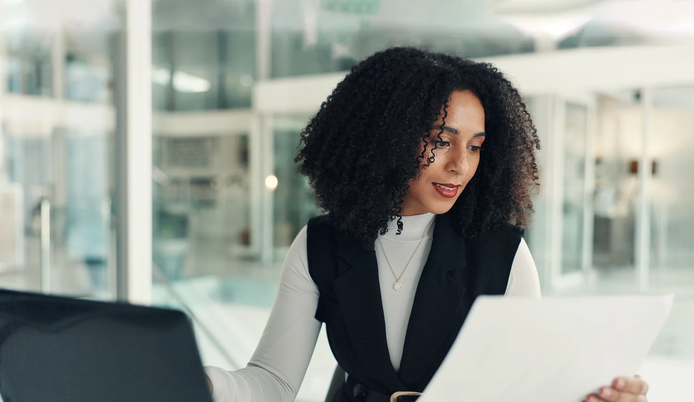 HR professional carefully reading over paperwork while working on site in a nonprofit's office
