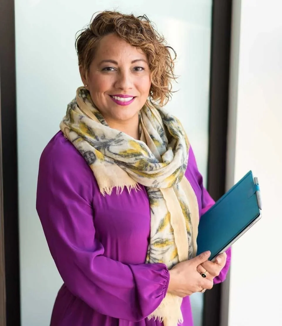 employee standing in front of office window with tablet