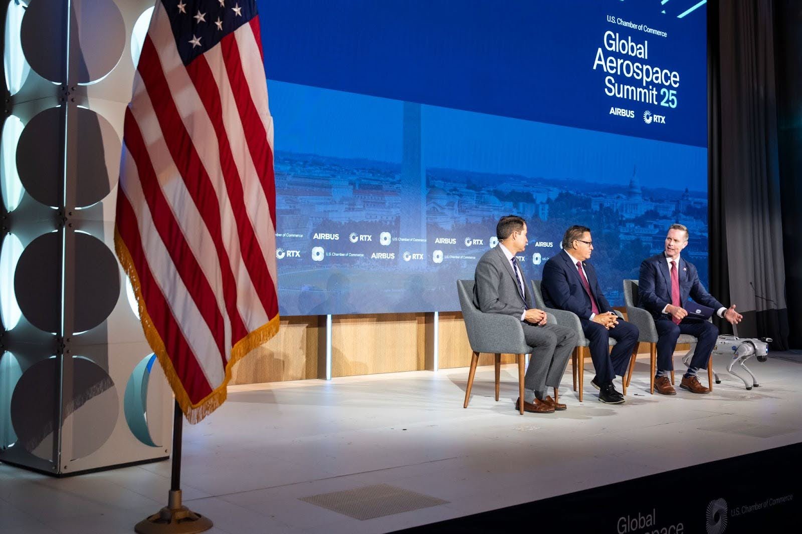 Three men on stage during a panel for the Global Aerospace Summit. Event produced by Washington D.C. based event production company Stratus Firm.