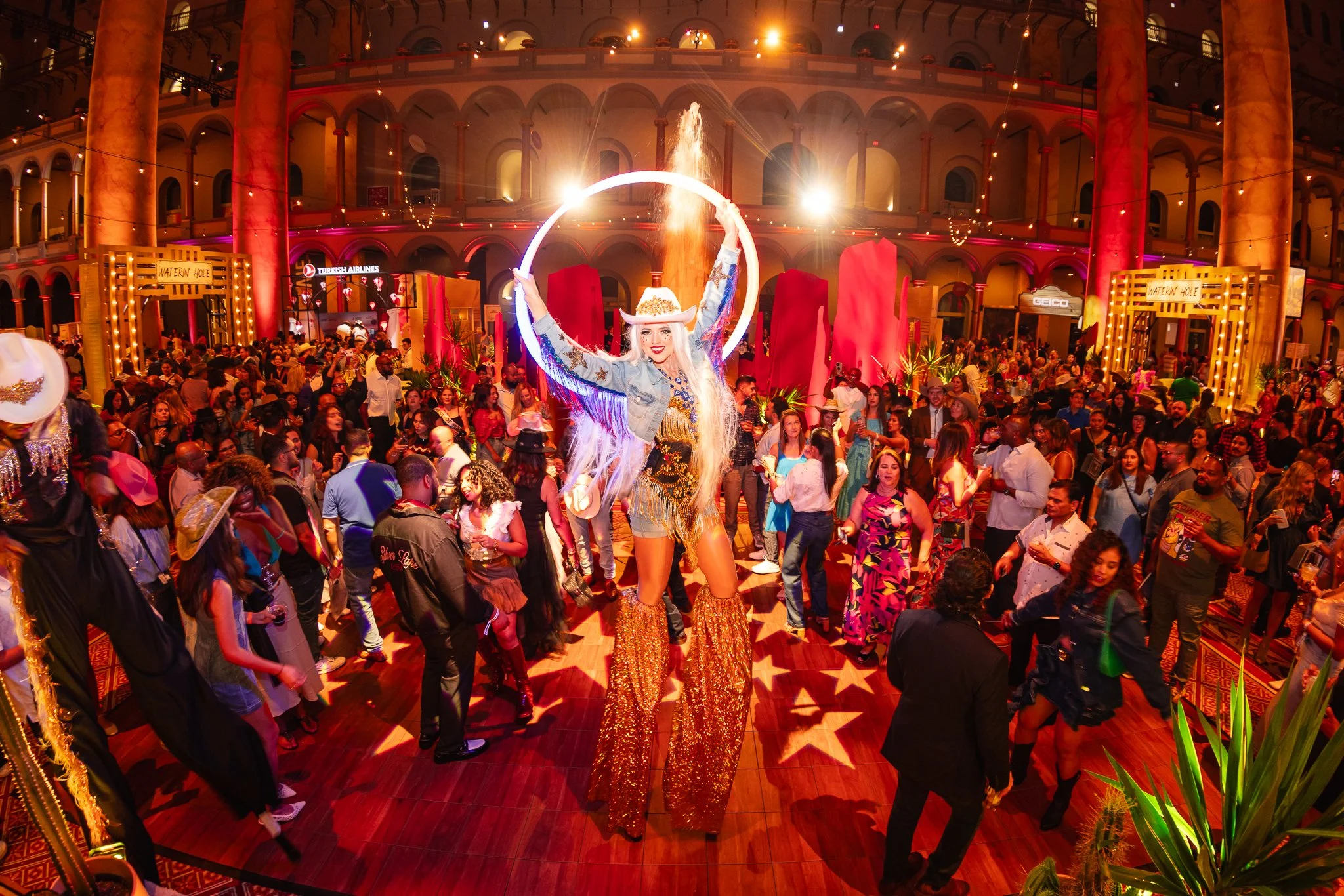 Female stilt walker with hula hoop on the dance floor at the Washingtonian Best of Washington culinary showcase in Washington D.C. Event produced by Stratus Firm, an event production agency located in Washington D.C.