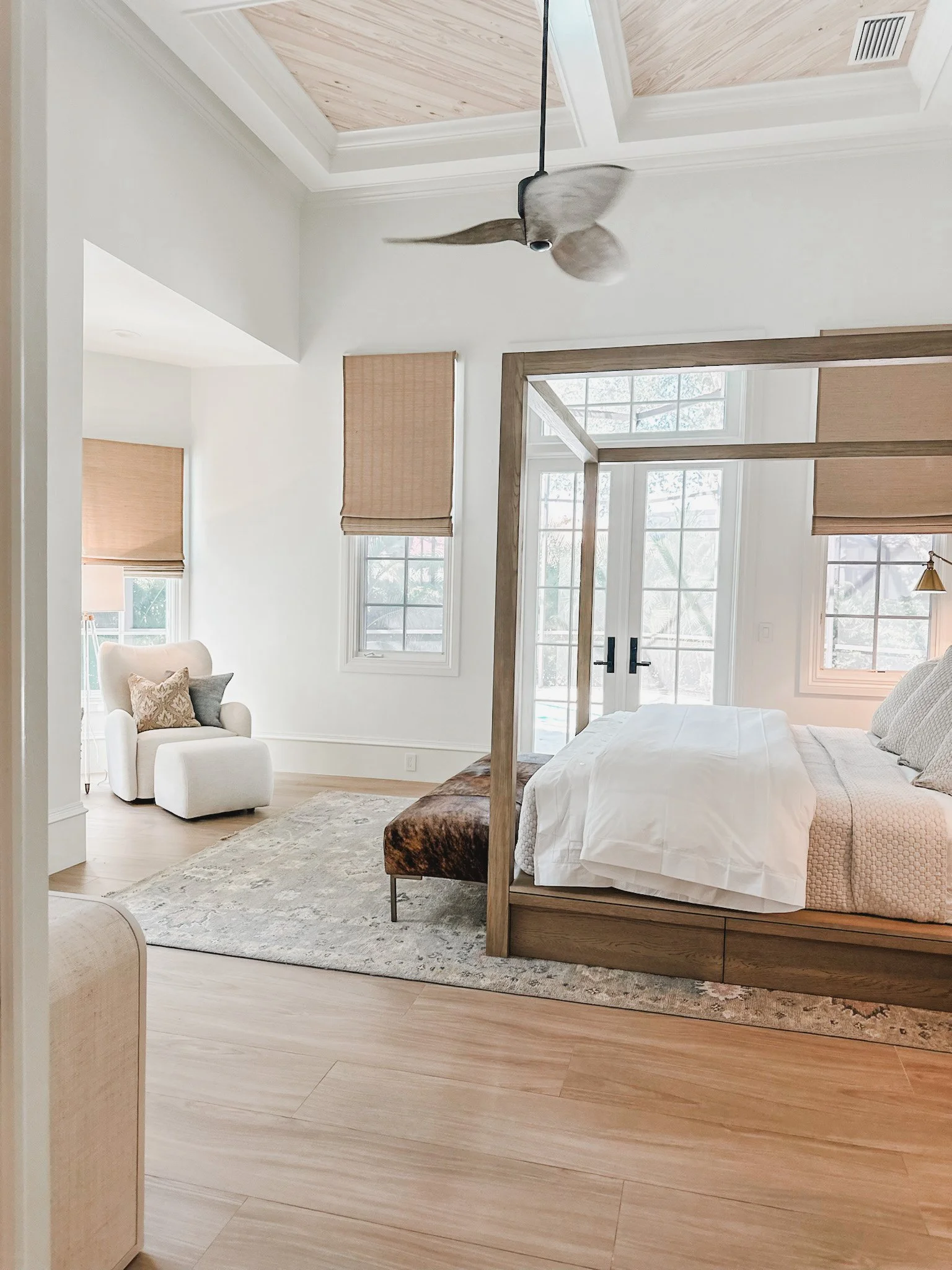 Naples bedroom with natural wood canopy bed, tall ceilings with wood inlays, and a ceiling fan in Naples Florida. 