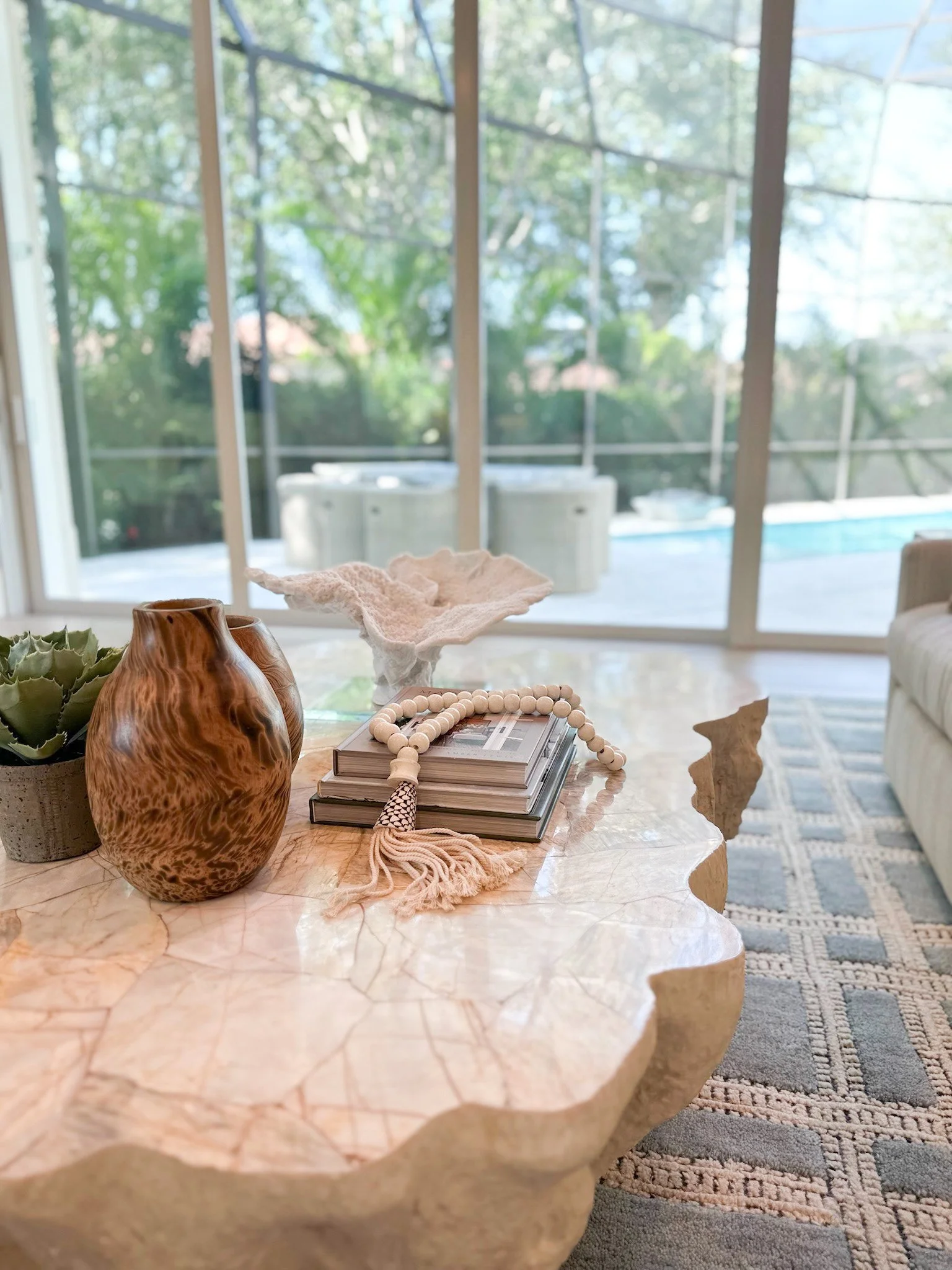Coffe table styled by Lark and Soul Interior design featuring books and coastal accent pieces in Naples Florida
