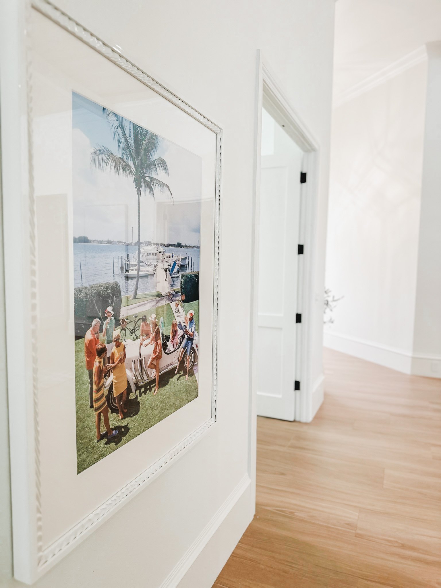 A Slim Aarons photograph capturing the golden age of wealth, privilege, beauty and leisure on the wall of a home in Naples. Florida.