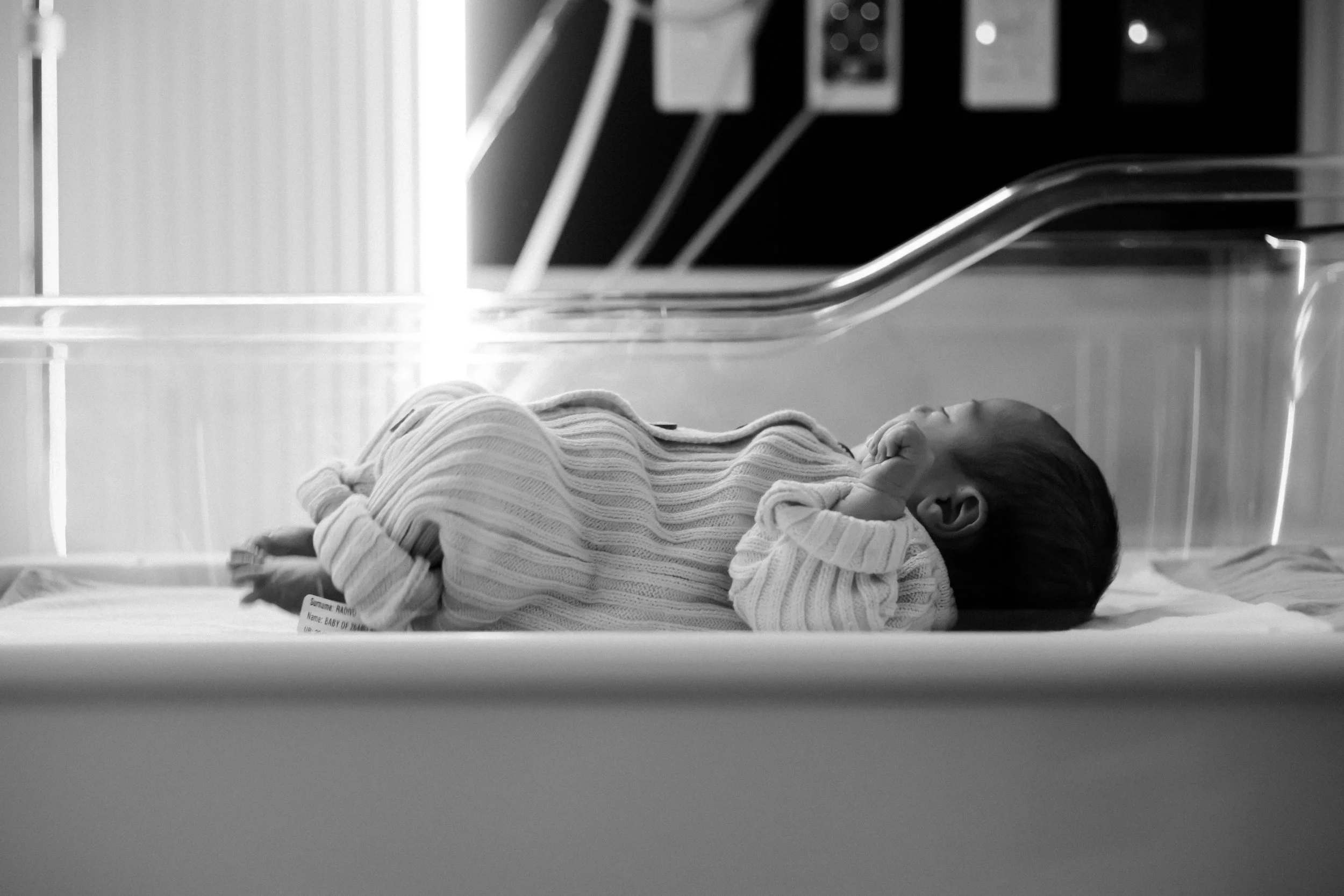 Newborn baby sleeping peacefully in hospital cot during a Fresh 48 newborn photography session in Geelong