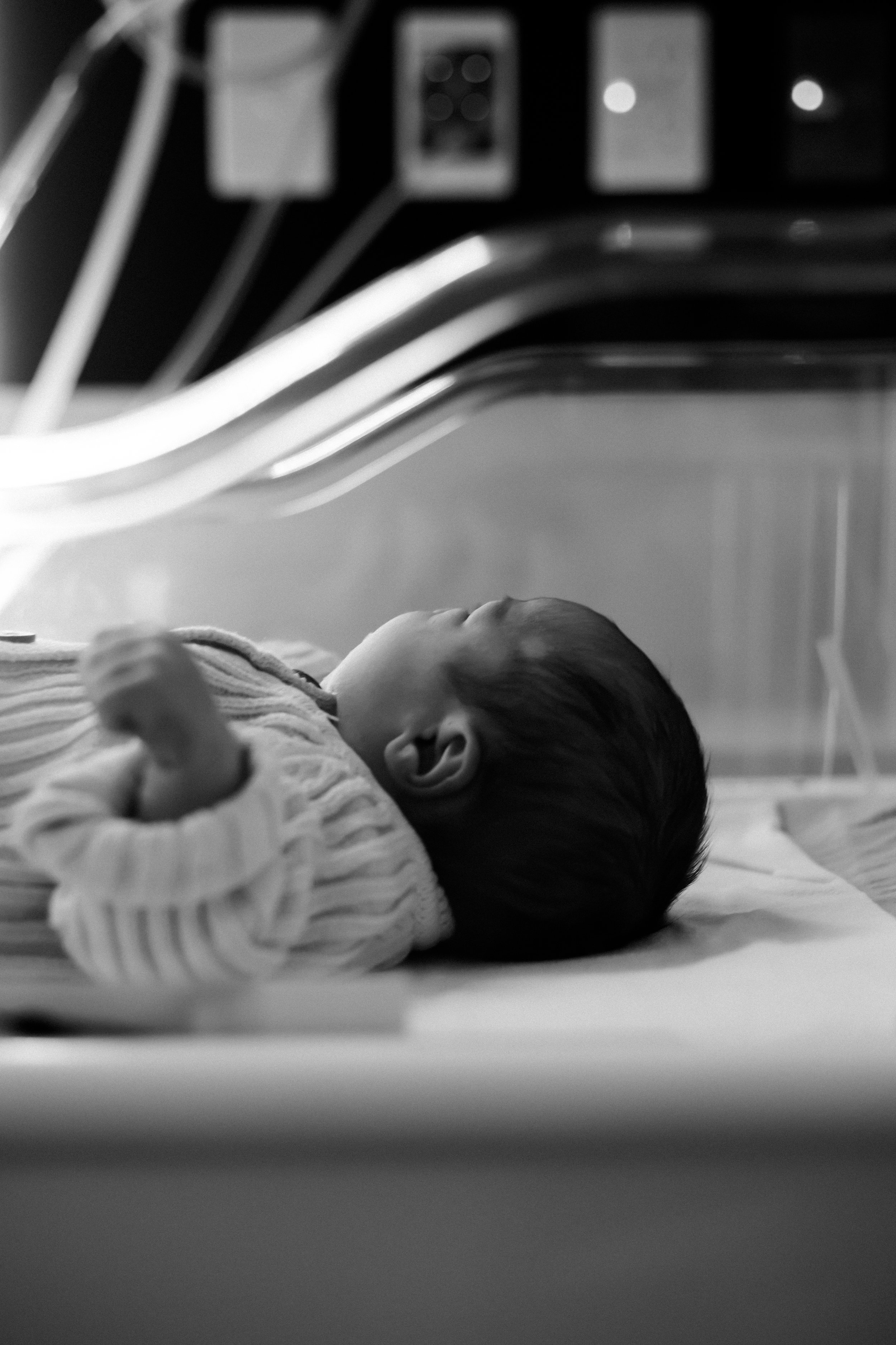 Newborn baby sleeping peacefully in hospital cot during a Fresh 48 newborn photography session in Geelong