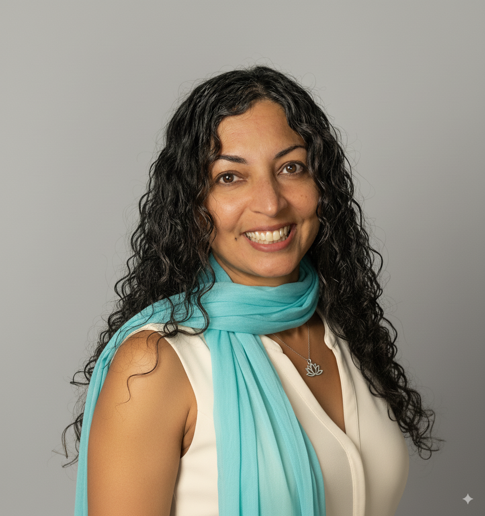 Monali is smiling against a blurred interior backdrop. She is wearing a black tshirt