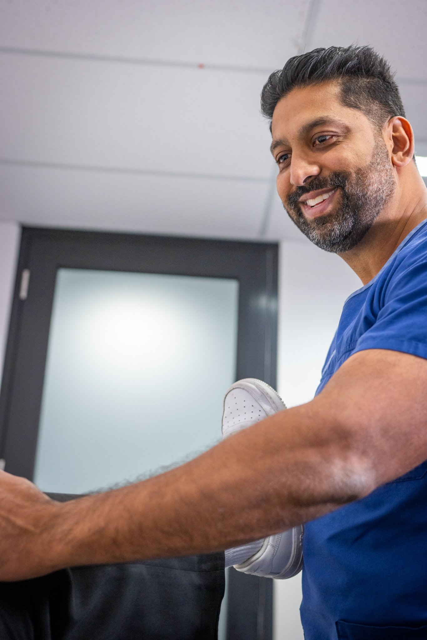 Dr Zee Arain consulting with a patient about knee pain