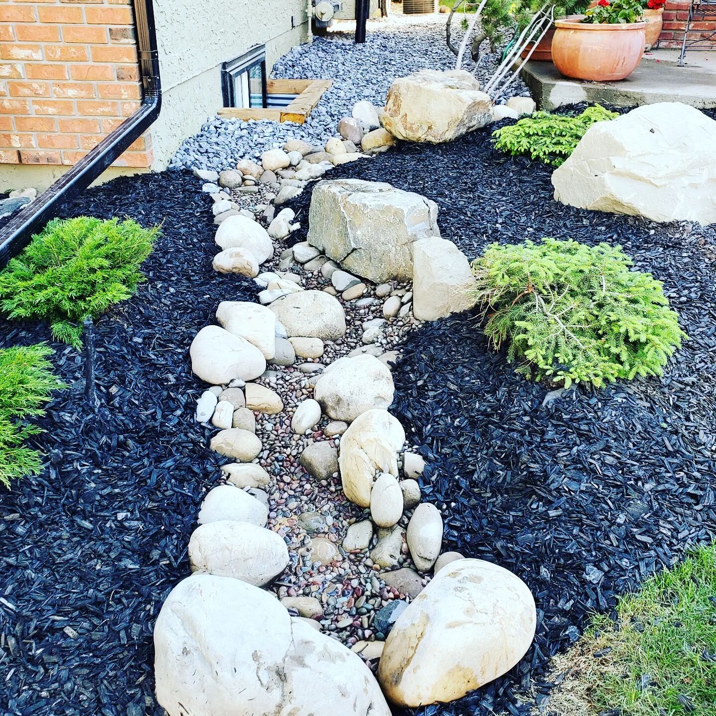 Dry creeks are the most creative and beautiful way to ensure proper water drainage.  Not only is this cosmetically pleasing to the eye, but also ensures that the water drains correctly.