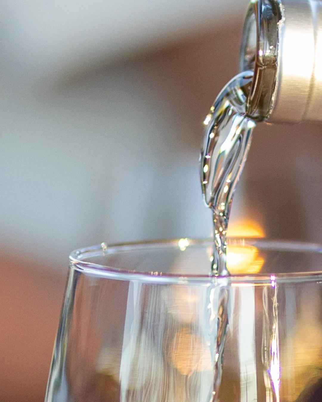 Close-up of wine being poured into a glass, photographed as part of a hospitality brand shoot.