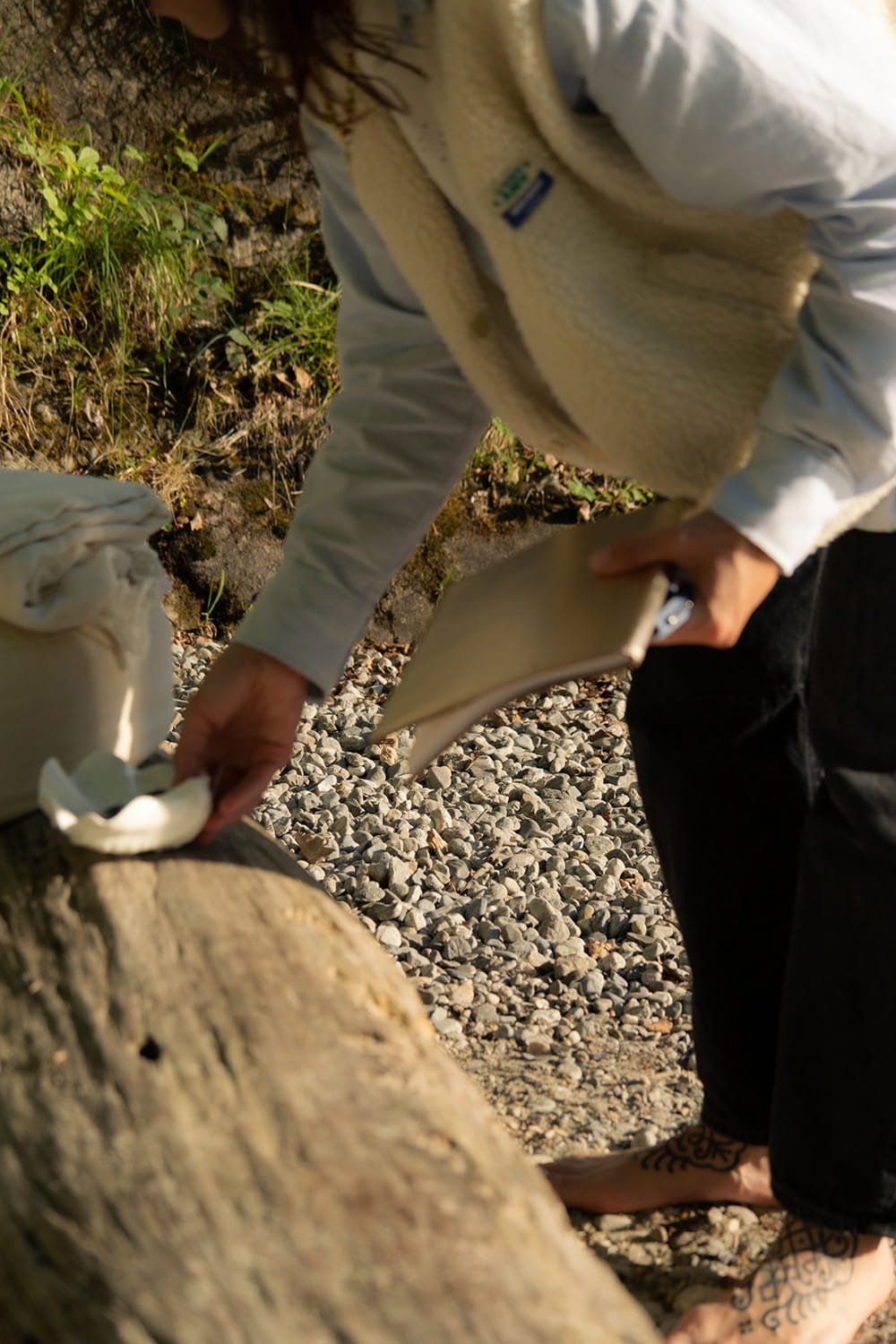 Jil Bianca on a pebble beach, preparing for the Creative Sphere online workshop for her community.