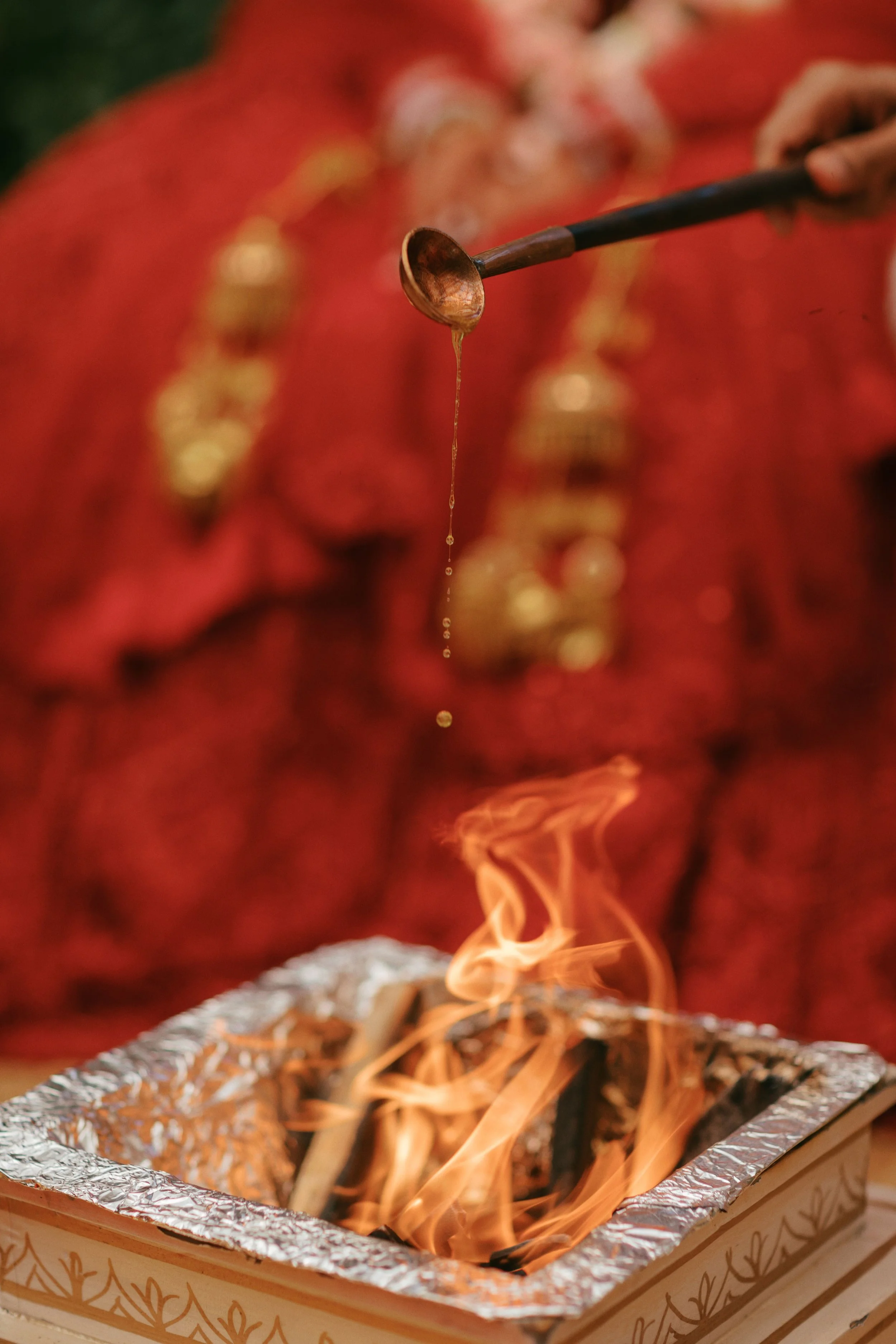 A small fire burning in a foil tray with flames and wisps of smoke rising above it.