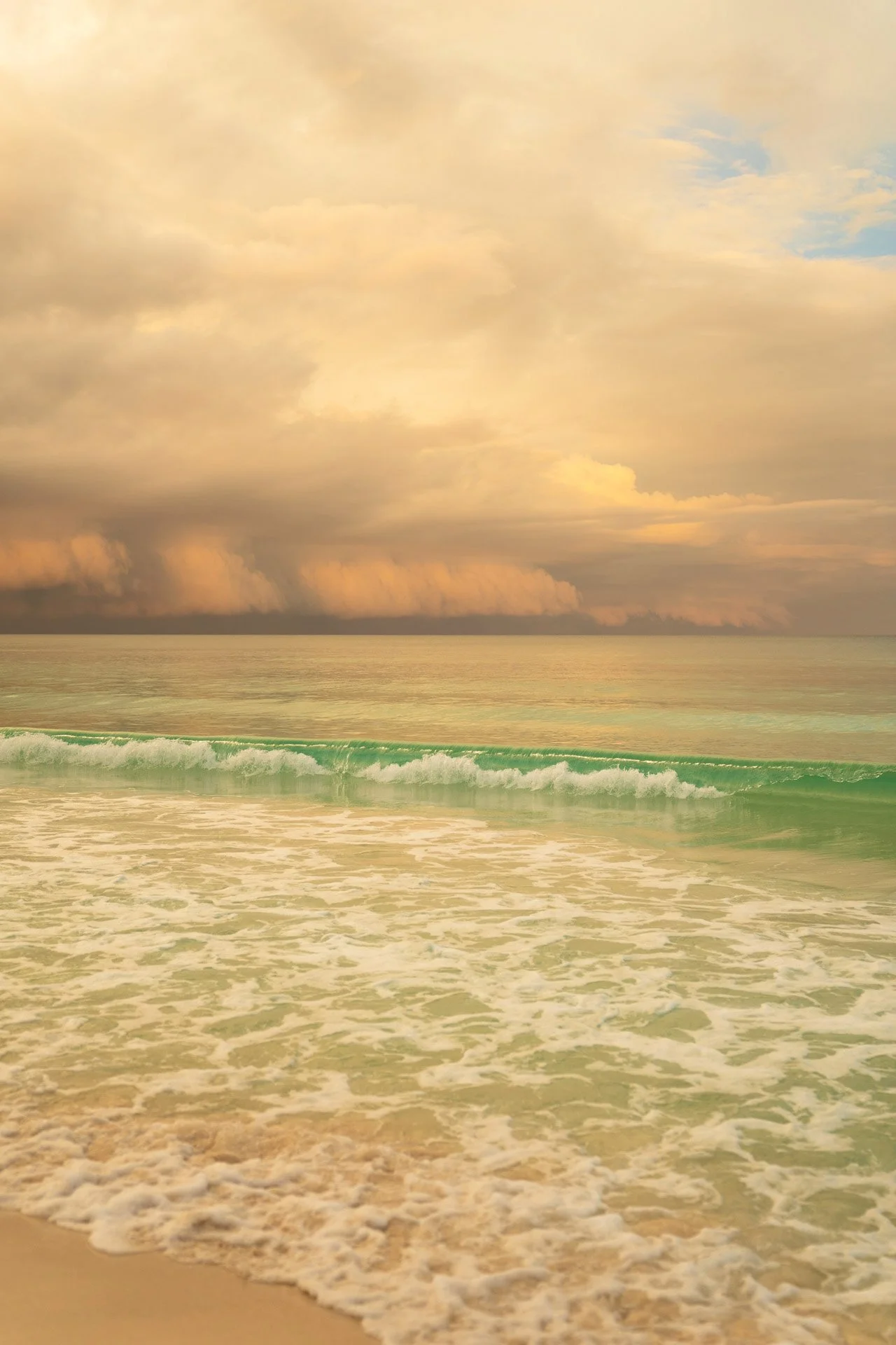 Beach with gentle waves and a cloudy sky during sunset