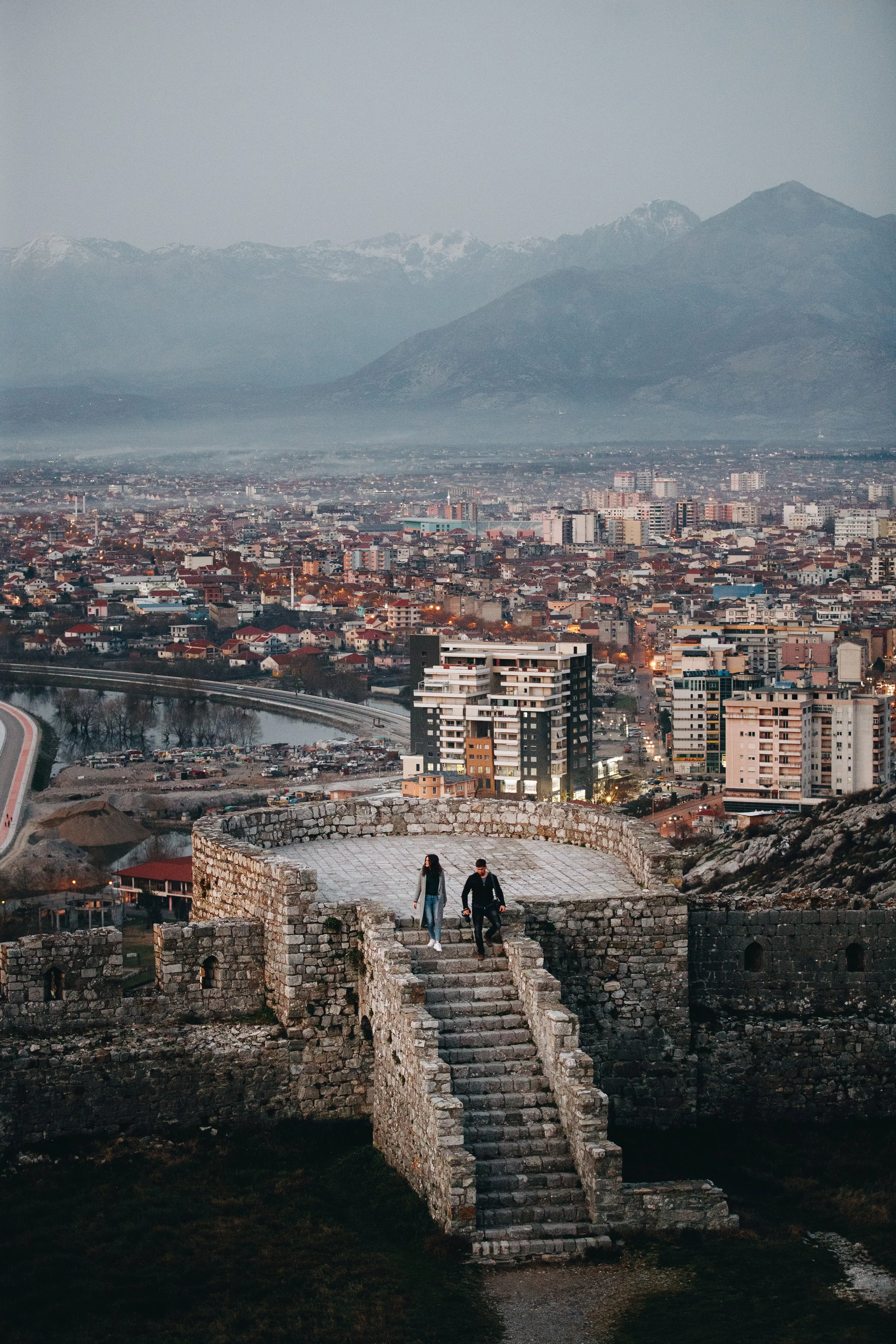 Stone fortress with cityscape and mountains in the background