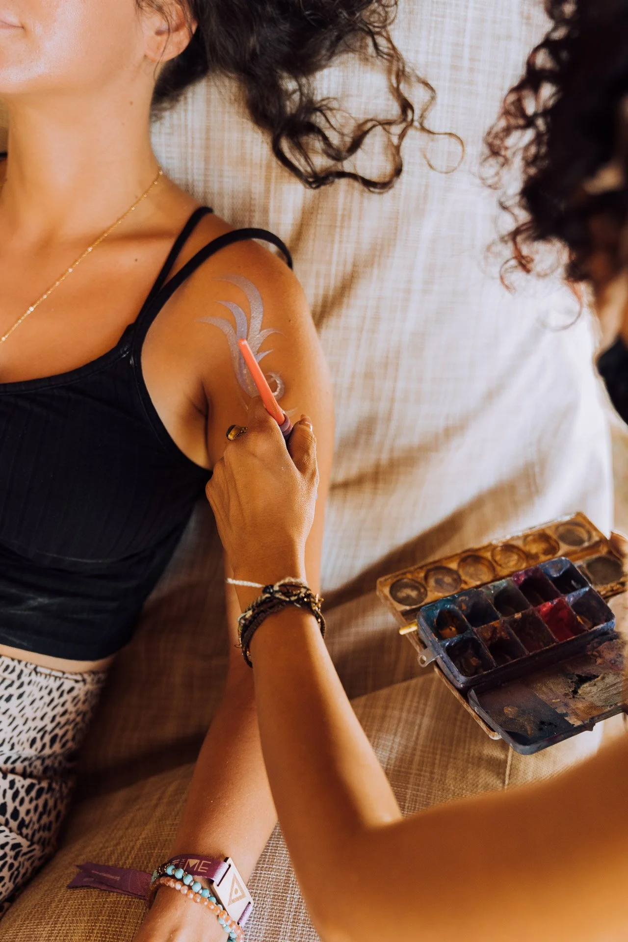 Person getting body paint on upper arm
