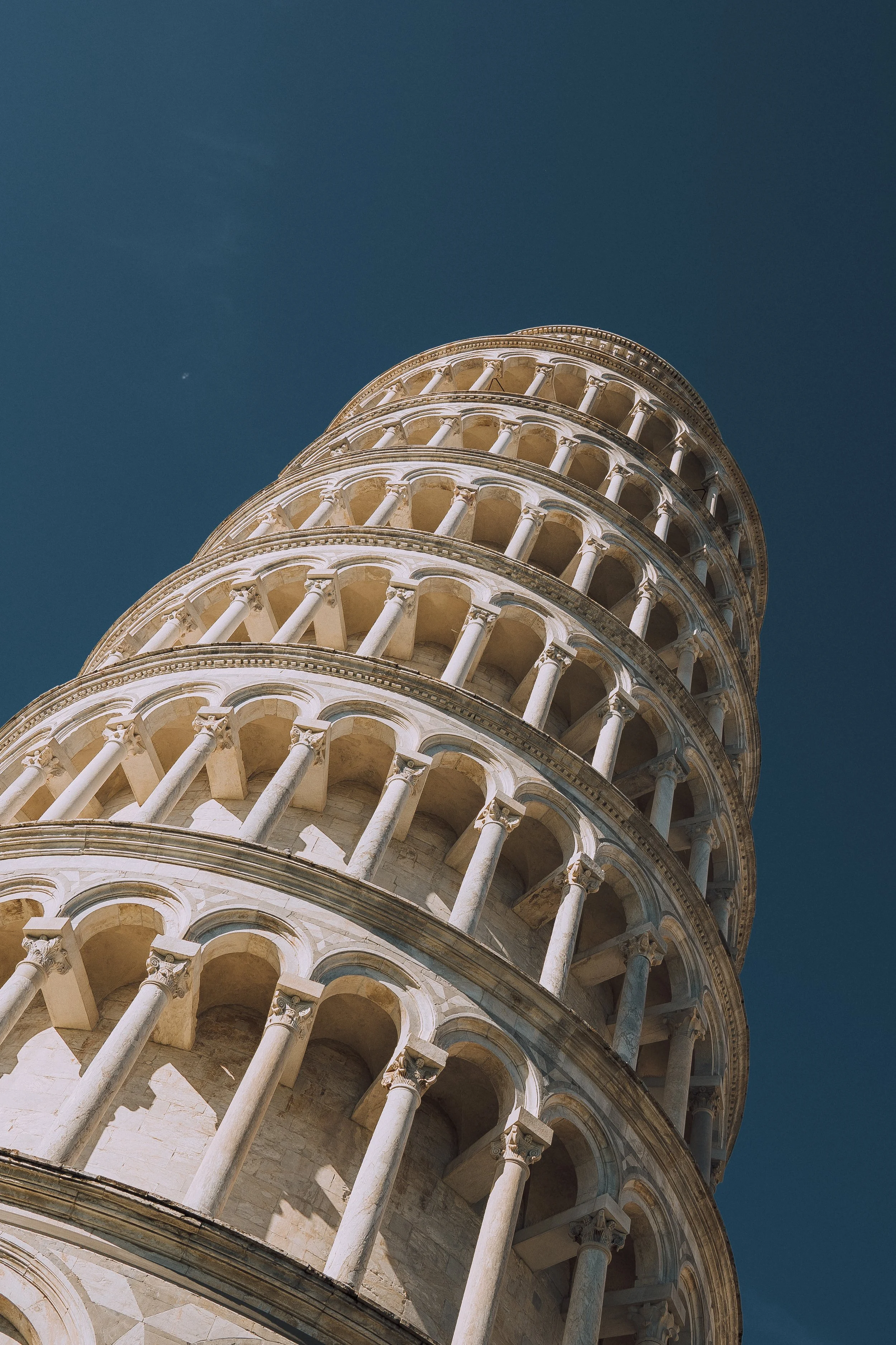 Leaning Tower of Pisa against blue sky, upward angle