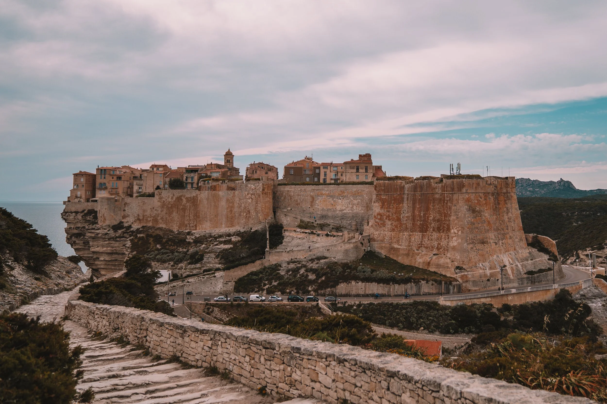 Historic town on a cliff, Bonifacio, Corsica, France, overlooking the sea with stone walls and buildings.
