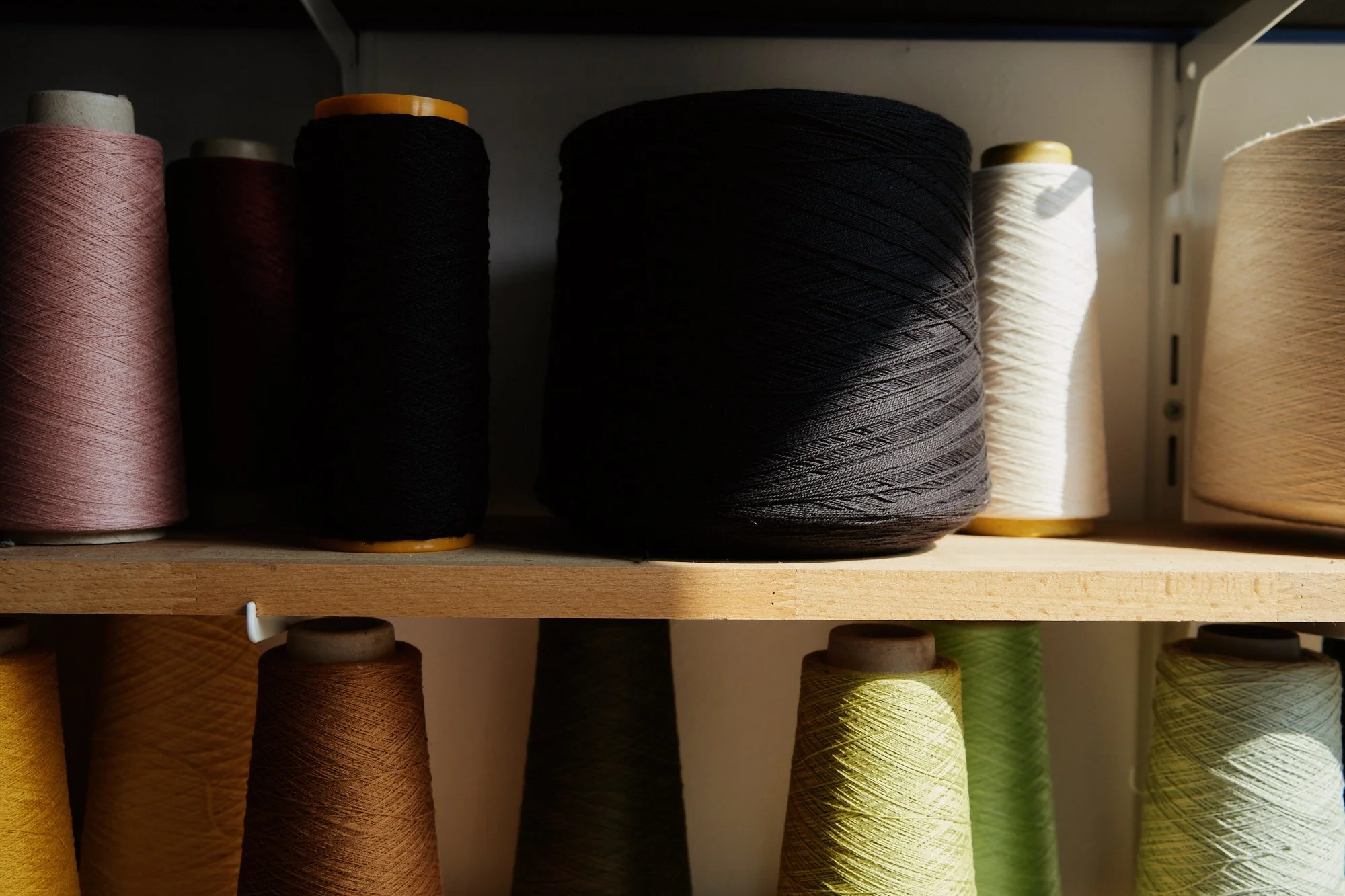 yarn cones on shelf sunlight