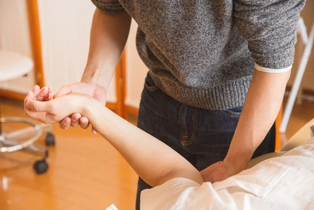 therapist performing nerve release technique on arm of patient laying on back