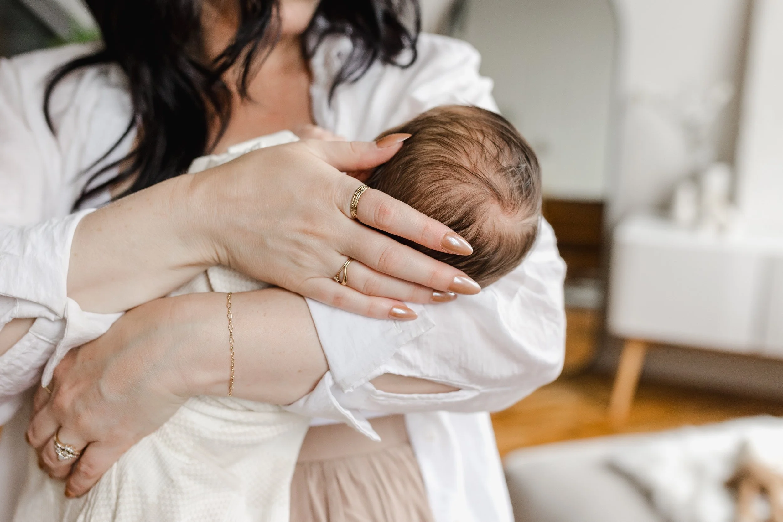 Parent holding a sleeping baby at home.