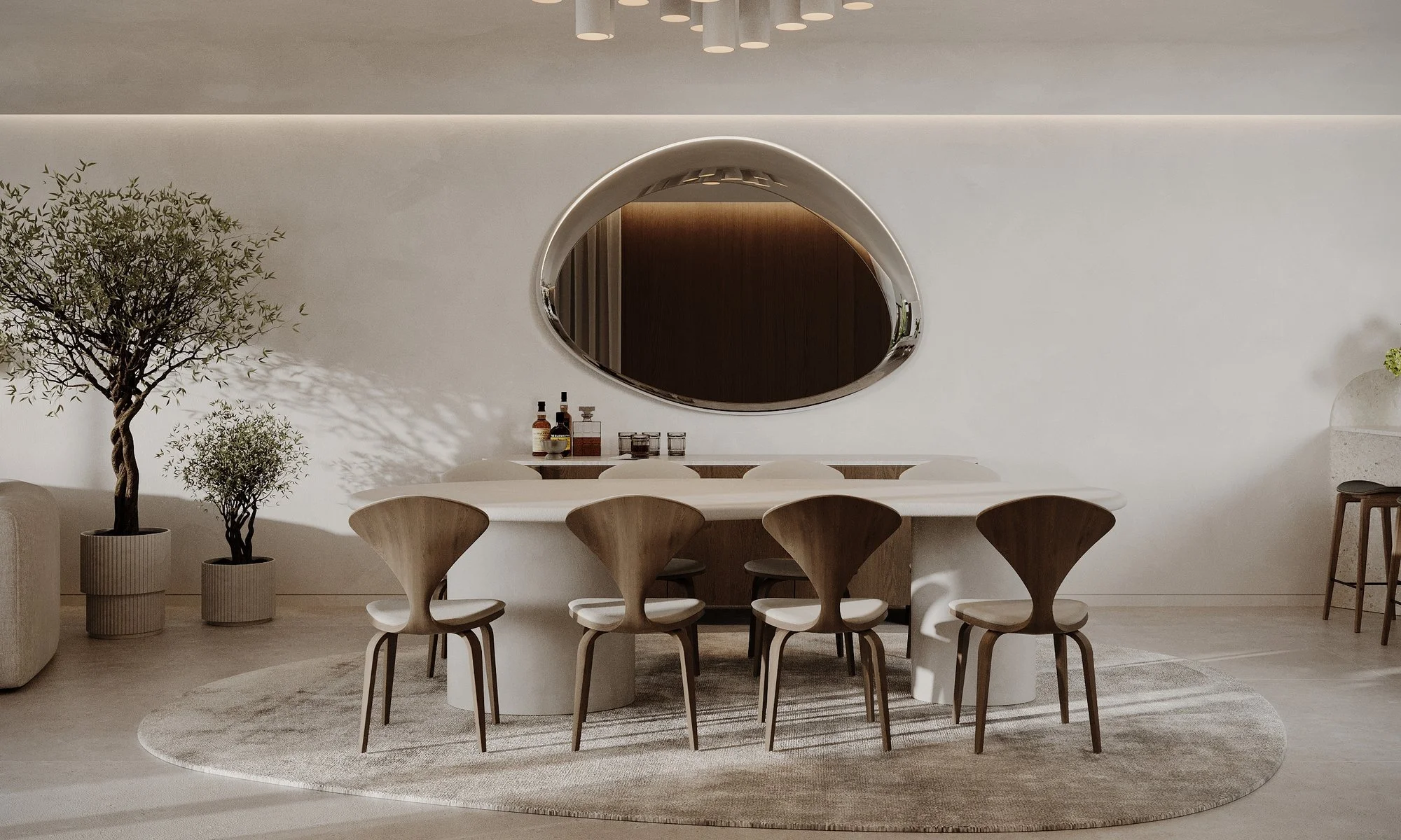 Comedor con mesa ovalada, sillas de madera y espejo de contorno irregular.