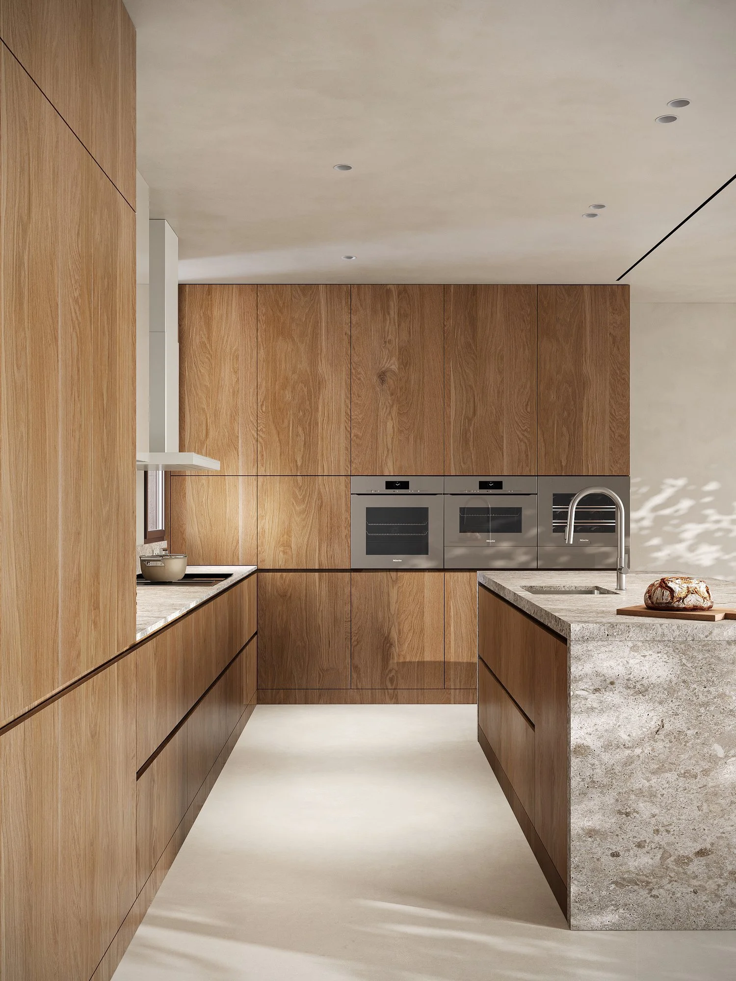 Cocina con frentes de madera e isla de acabado pétreo.