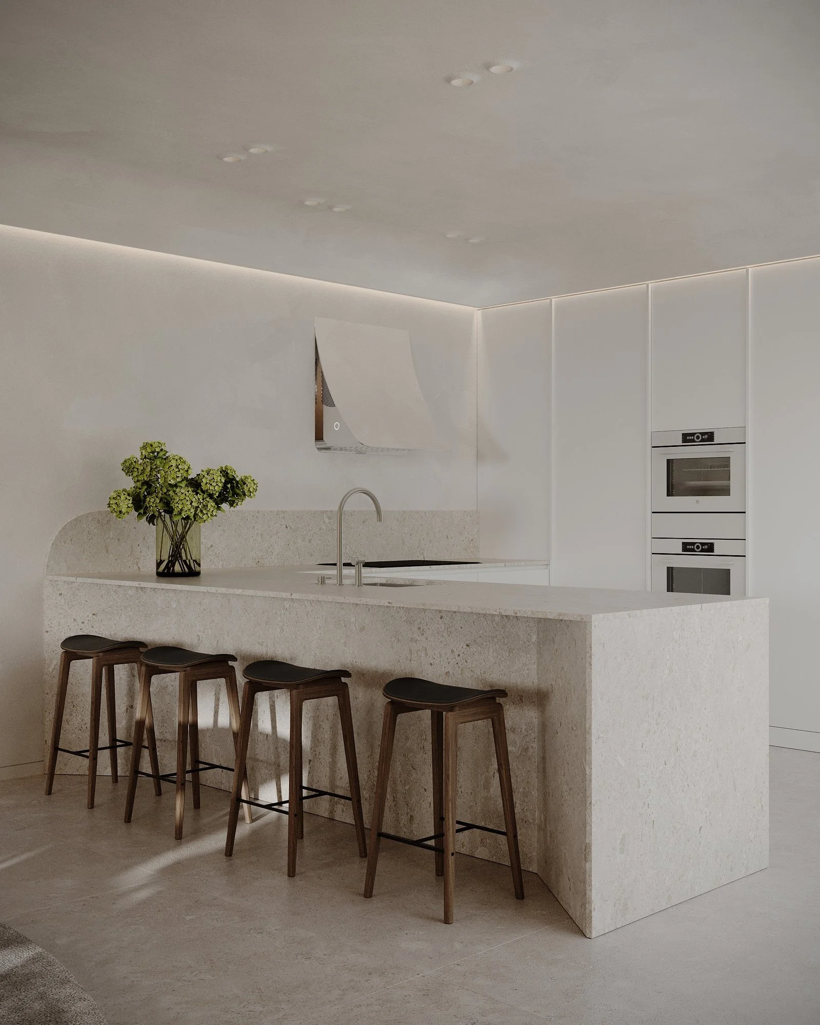 Cocina clara con isla, taburetes de madera y luz indirecta.