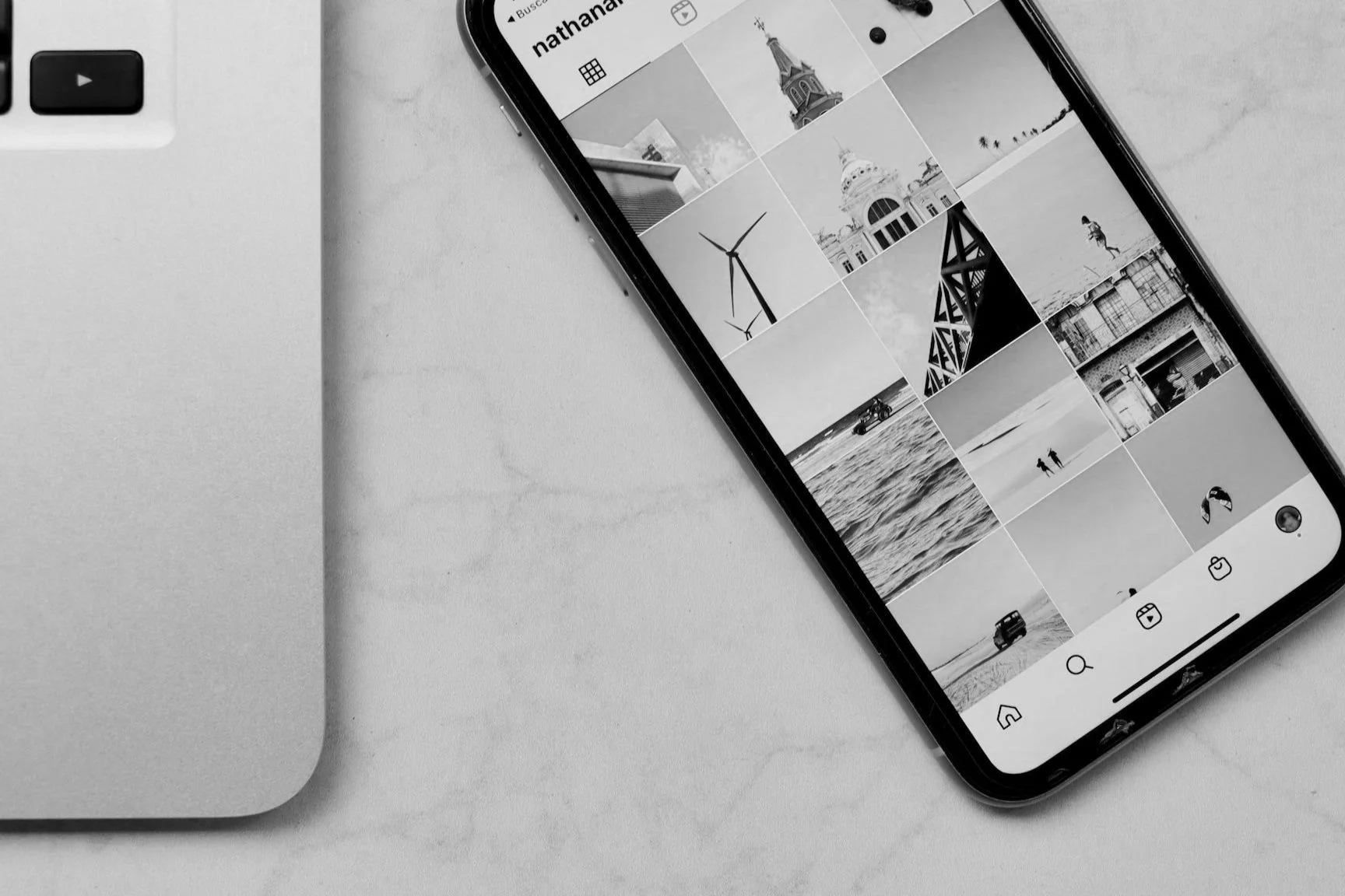 A close-up image of a phone with the Instagram grid interface shown.