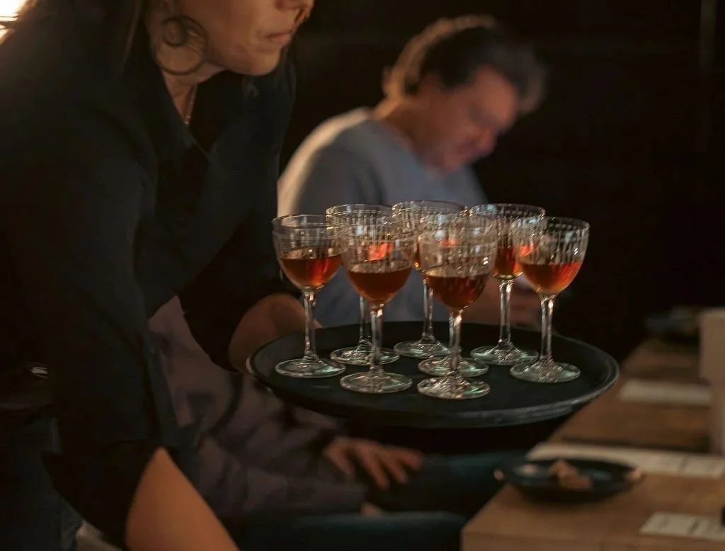 Porterhouse server presenting whiskey for tasting on a platter