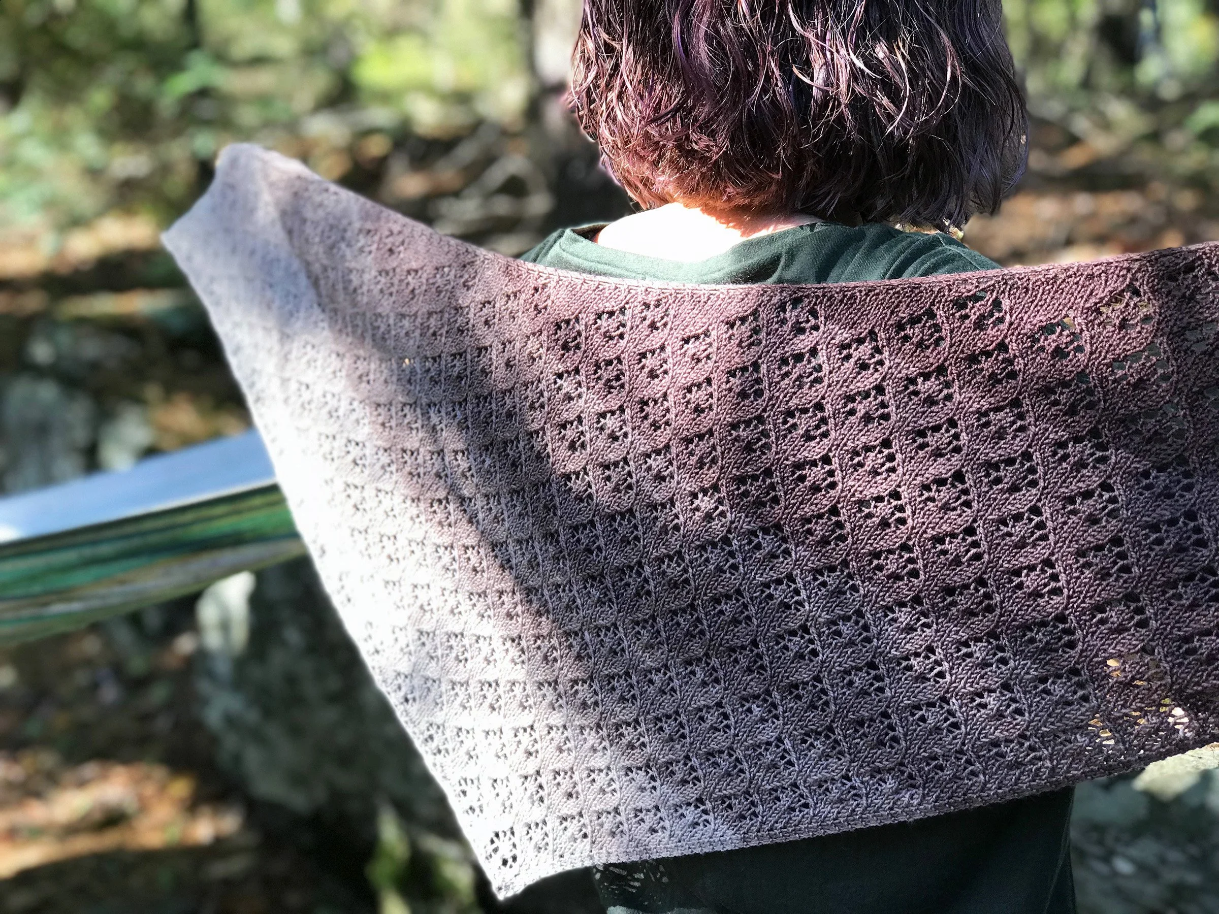 A modeled photo of a lace shawl in a gradient brown colorway.