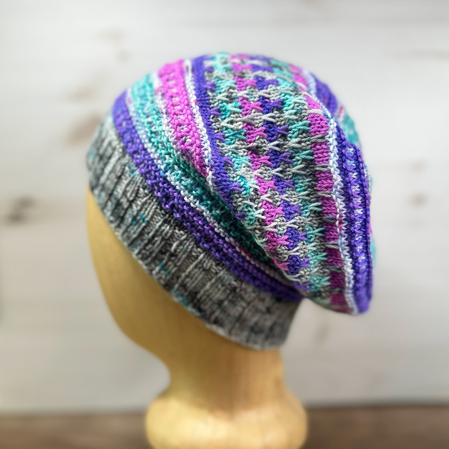 Neon striped hat on a mannequin head on a light background.