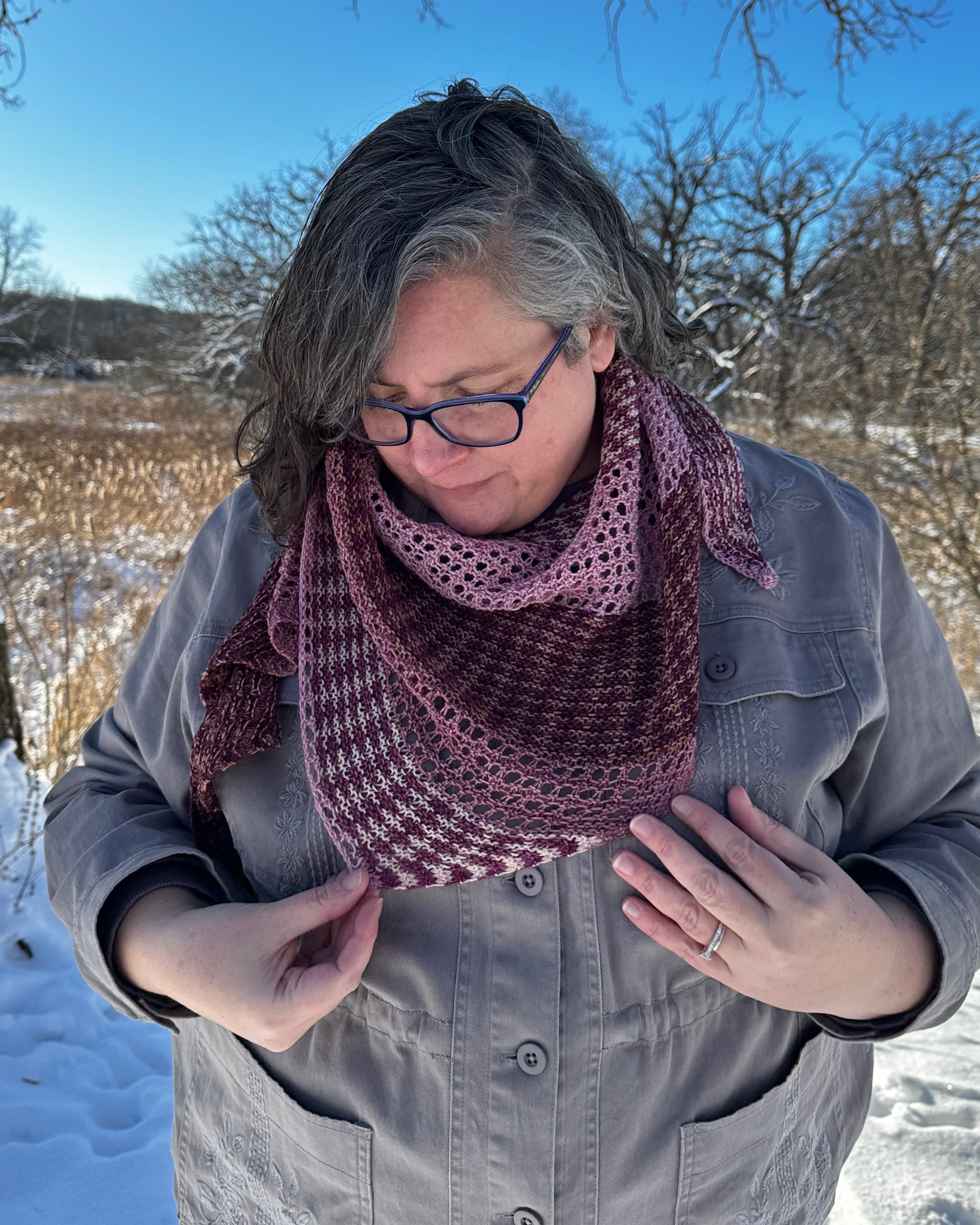 Modeled photo of a striped and lace hand knit shawl.