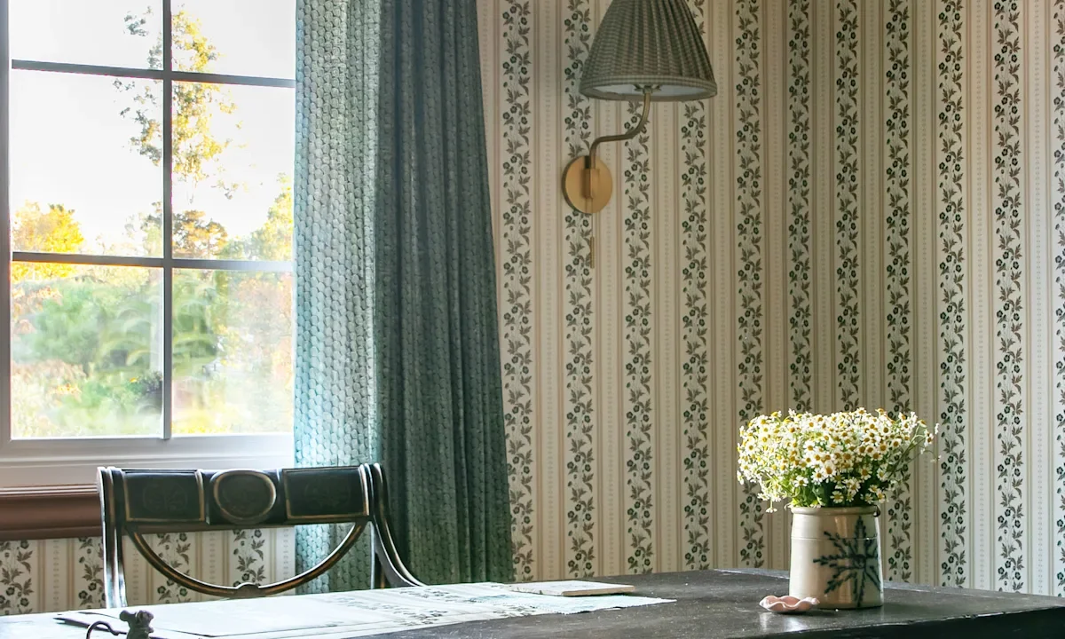 A room with buttercup stripe wallpaper designed by Abigail Bryan
