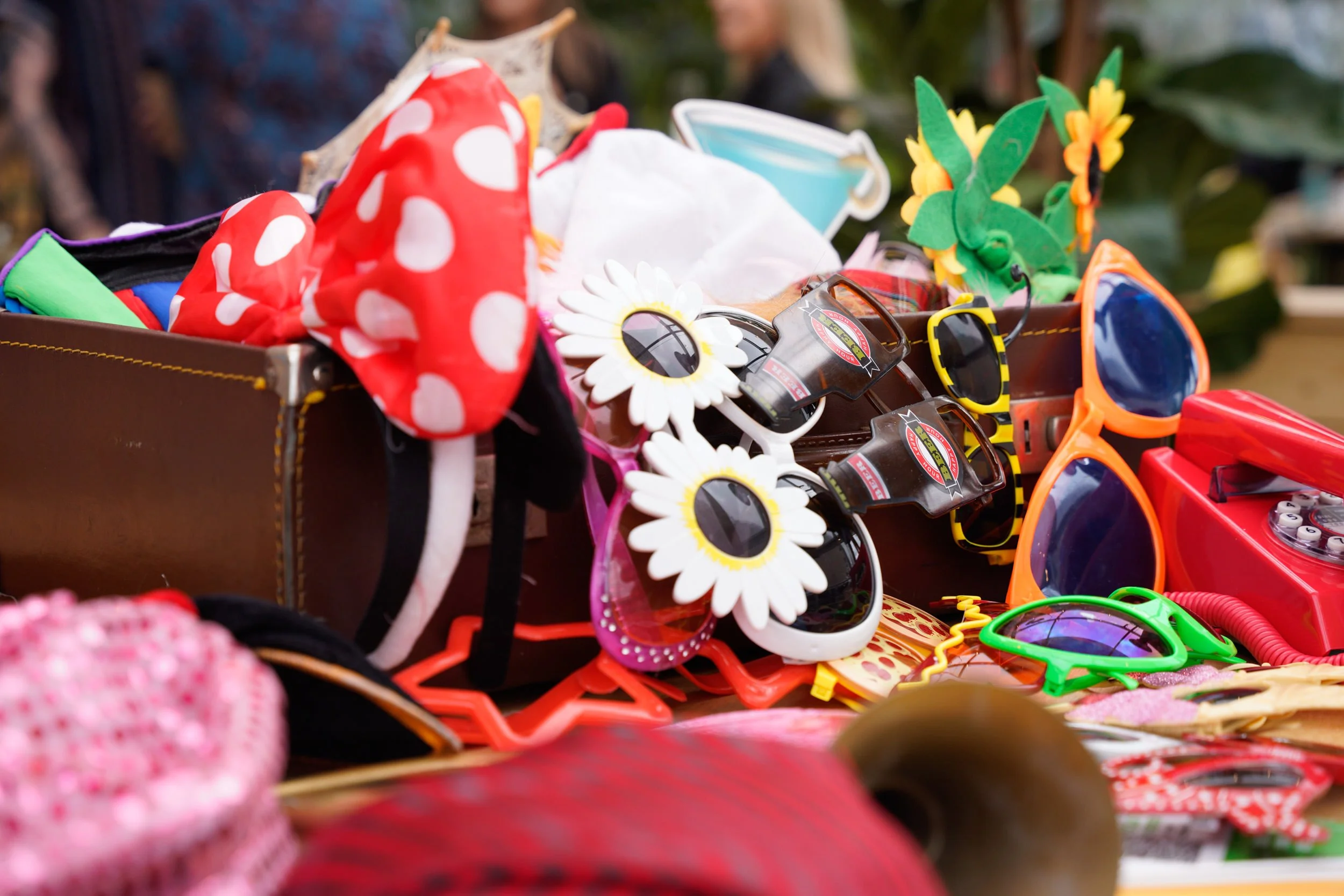 A collection of colorful children's toys and accessories including sunglasses, playful hats, and decorative items on a table.