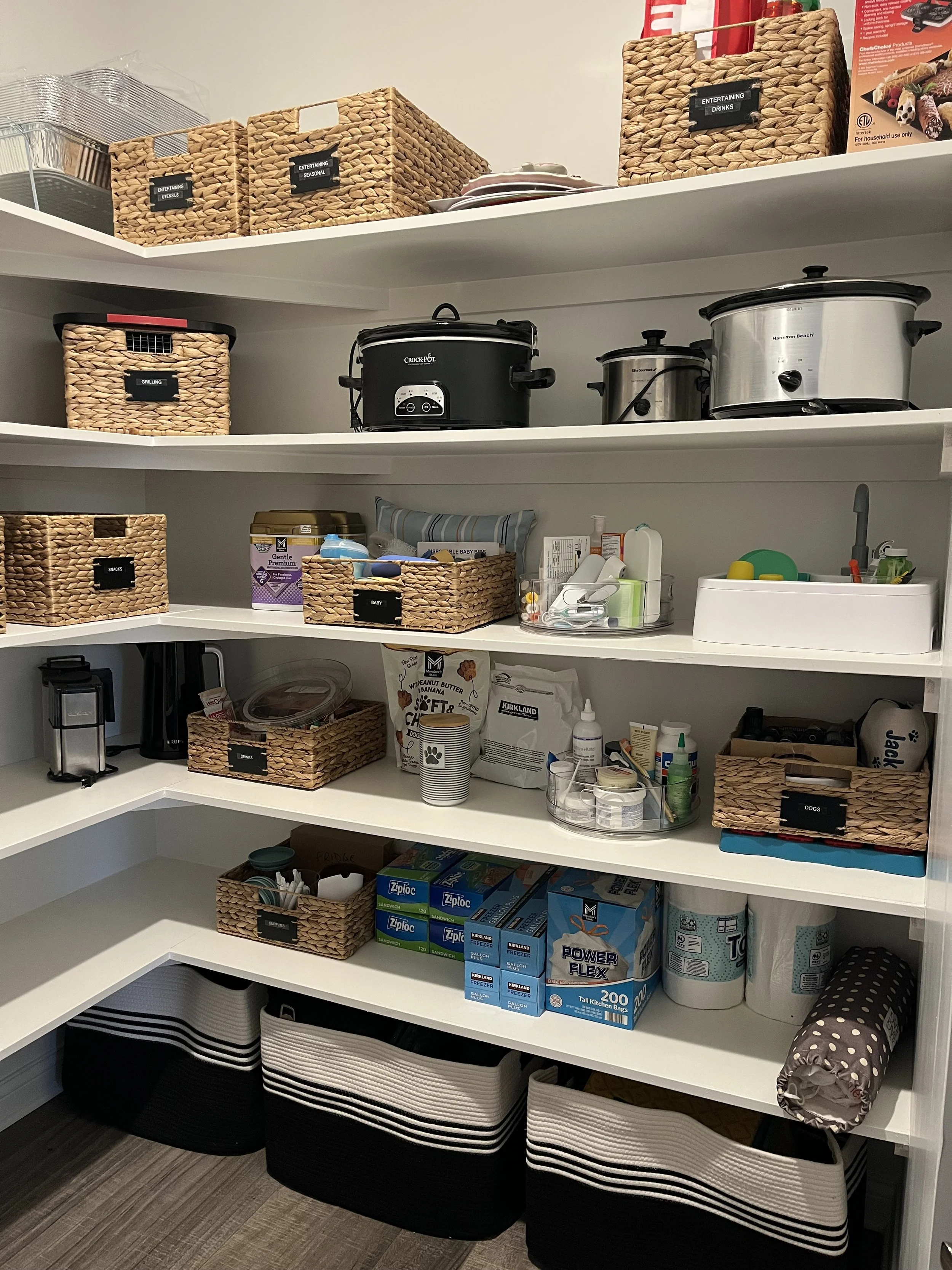 organized pantry showing small appliances, matching baskets, and large floor woven baskets