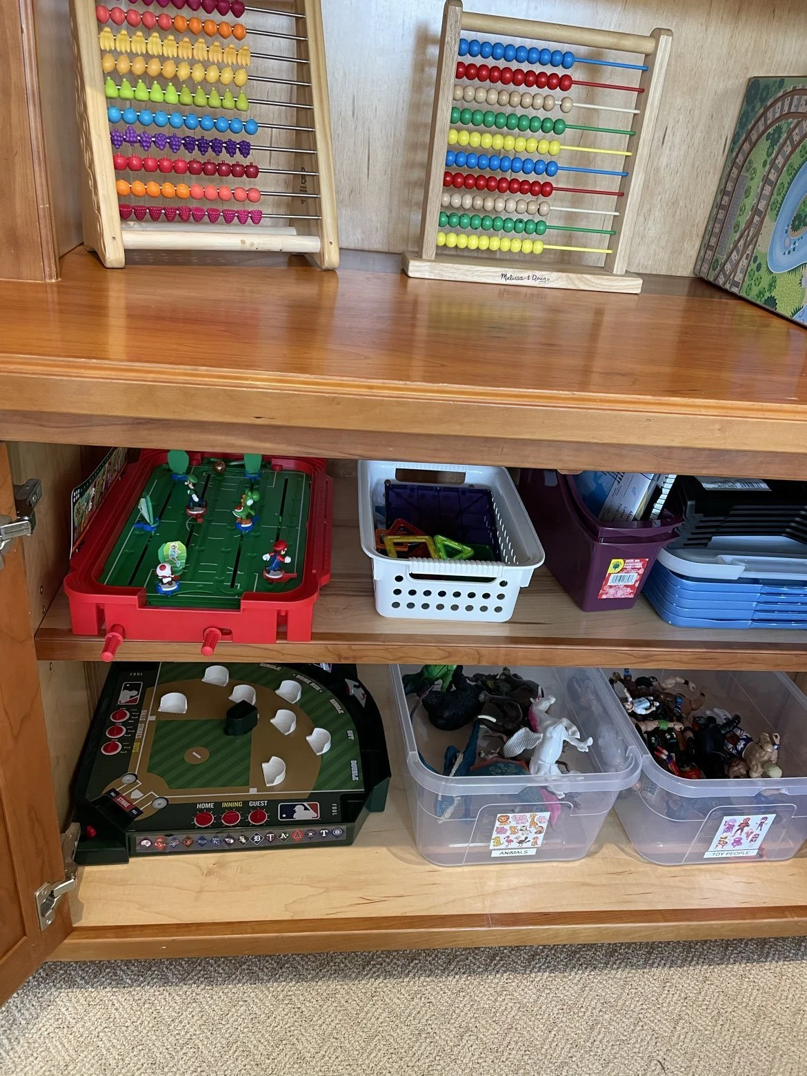 tidy and neat playroom cabinet in Bratenahl, Ohio after organizing by Declutter with Devon