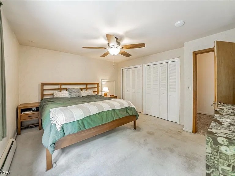 Neat and tidy bedroom with green bedspread in Moreland Hills, Ohio after professional organizing by Declutter with Devon