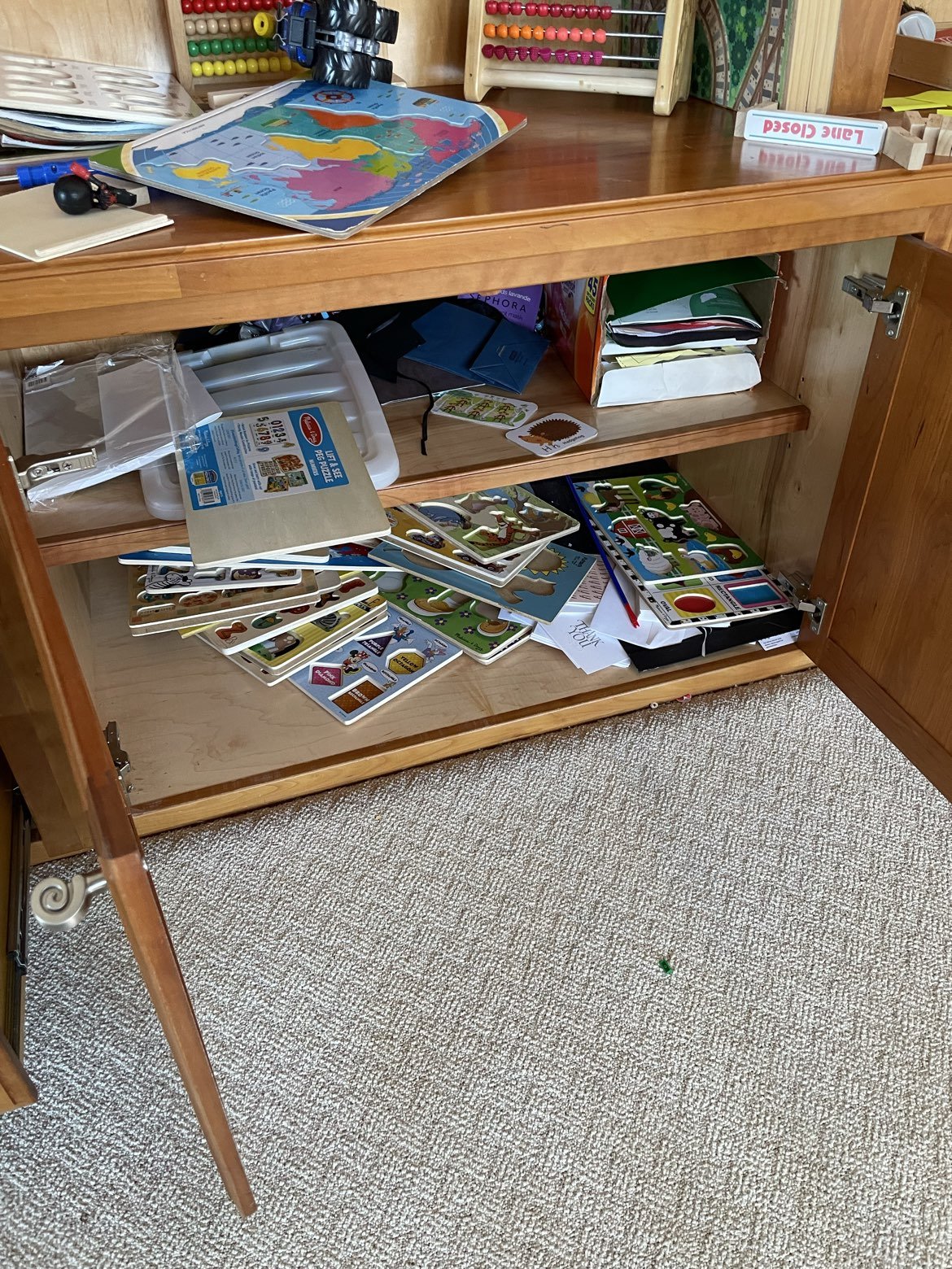 cluttered and messy playroom cabinet in Bratenahl, Ohio before organizing