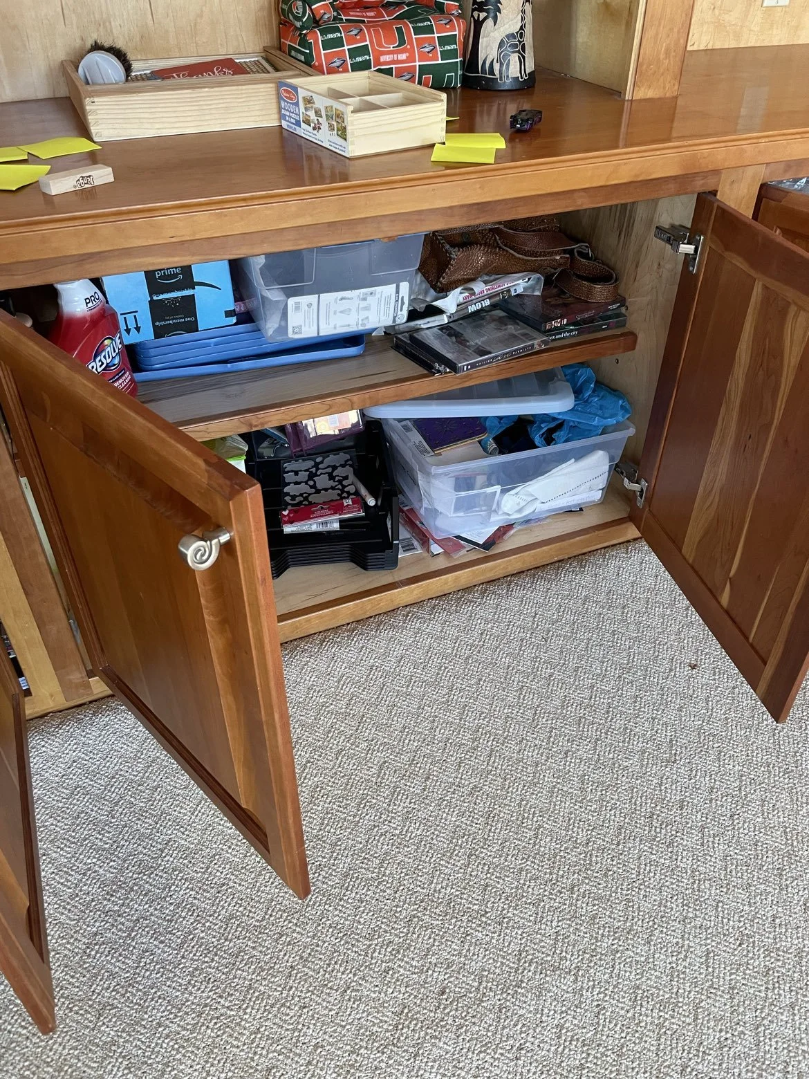 cluttered and messy playroom cabinet in Bratenahl, Ohio before organizing