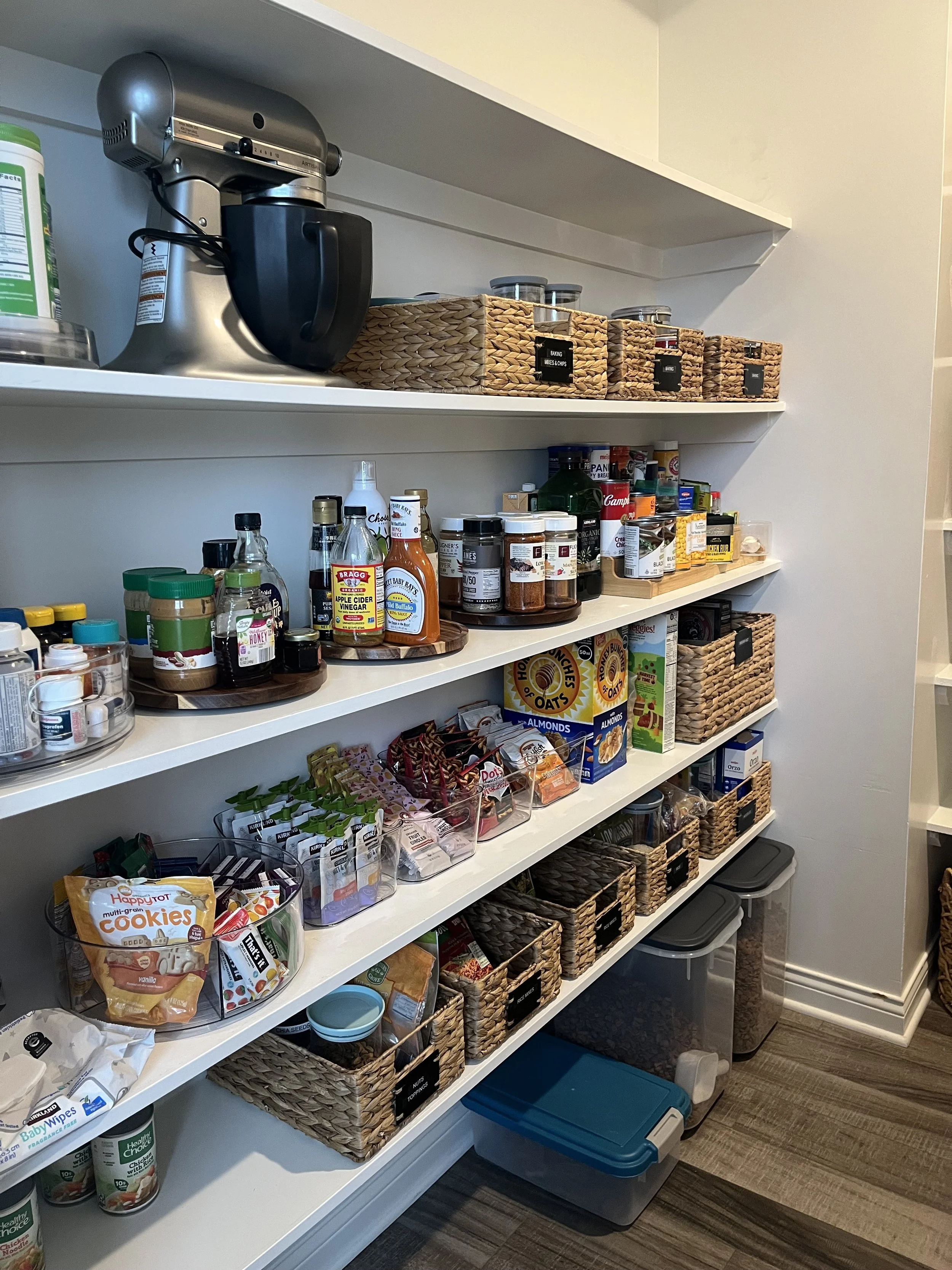 Organized pantry showing natural wicker baskets holding food