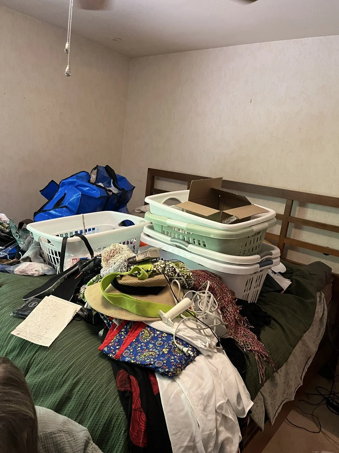laundry baskets and laundry clutter on the bed in Moreland Hills, Ohio before decluttering