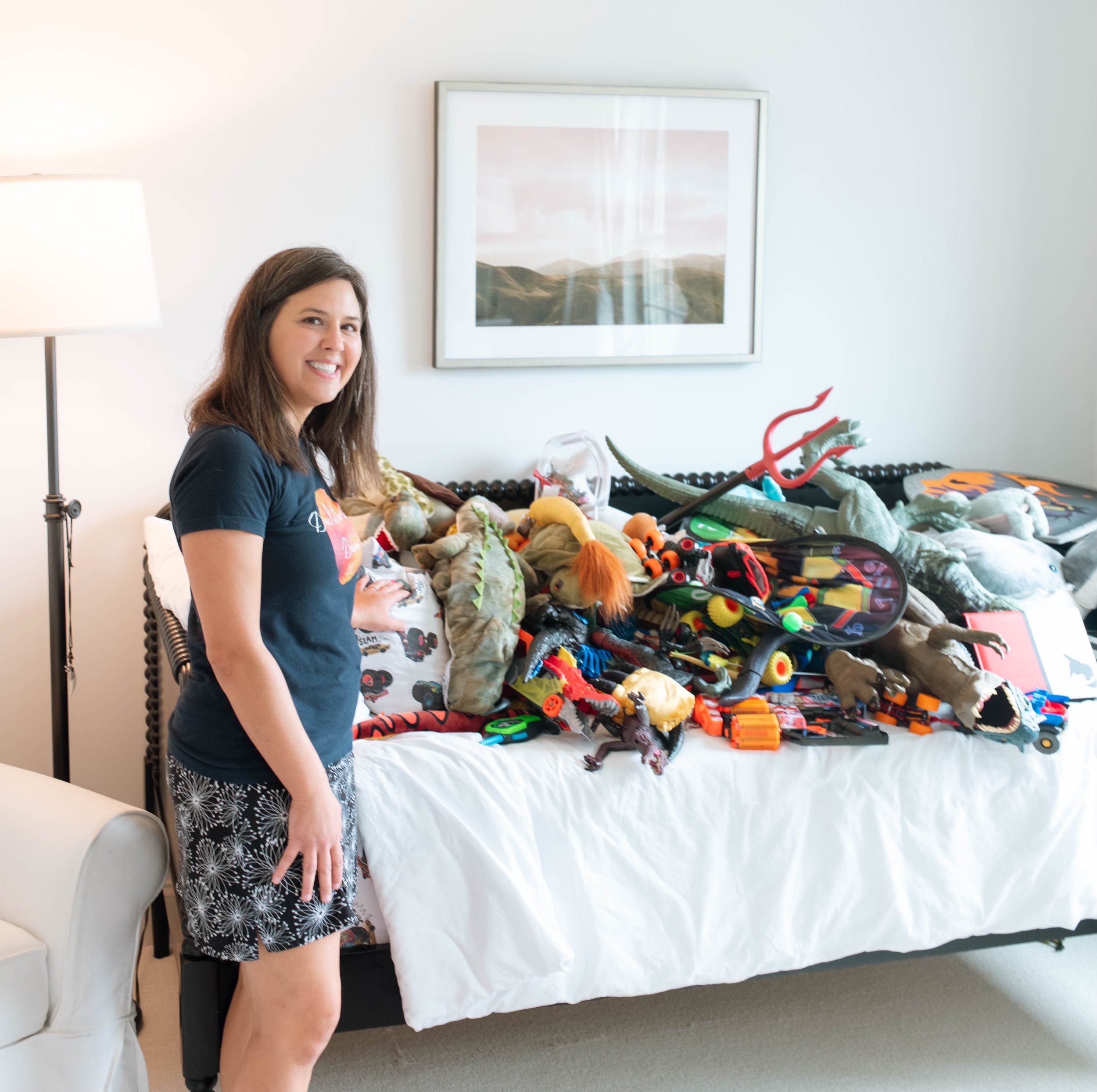 Devon standing next to a bed full of toys