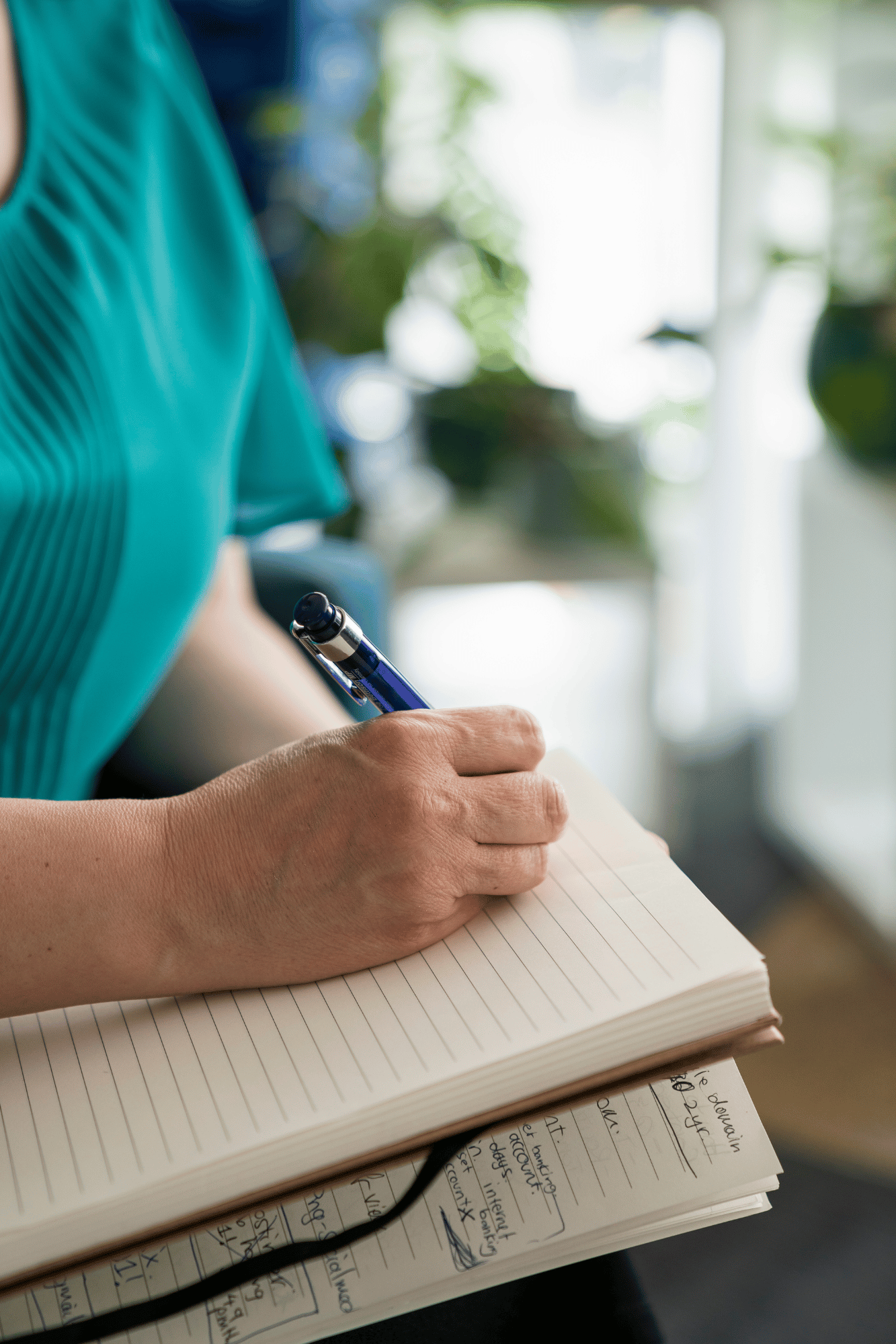 Hand writing in a notebook — representing the personalised curriculum built during the Implementation phase
