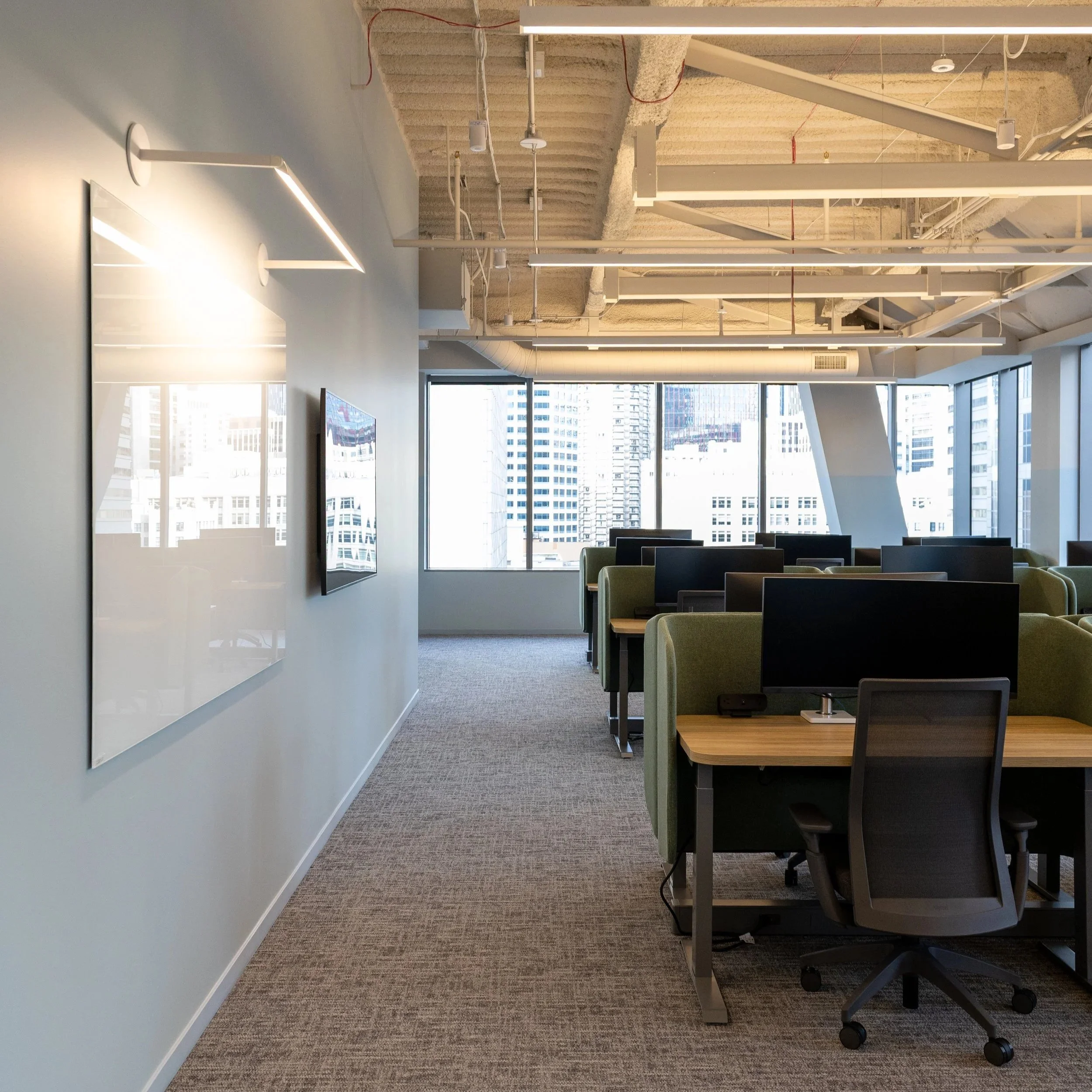 Modern Comfortable workspace design in office in Seattle, WA featuring individual desks with green backing
