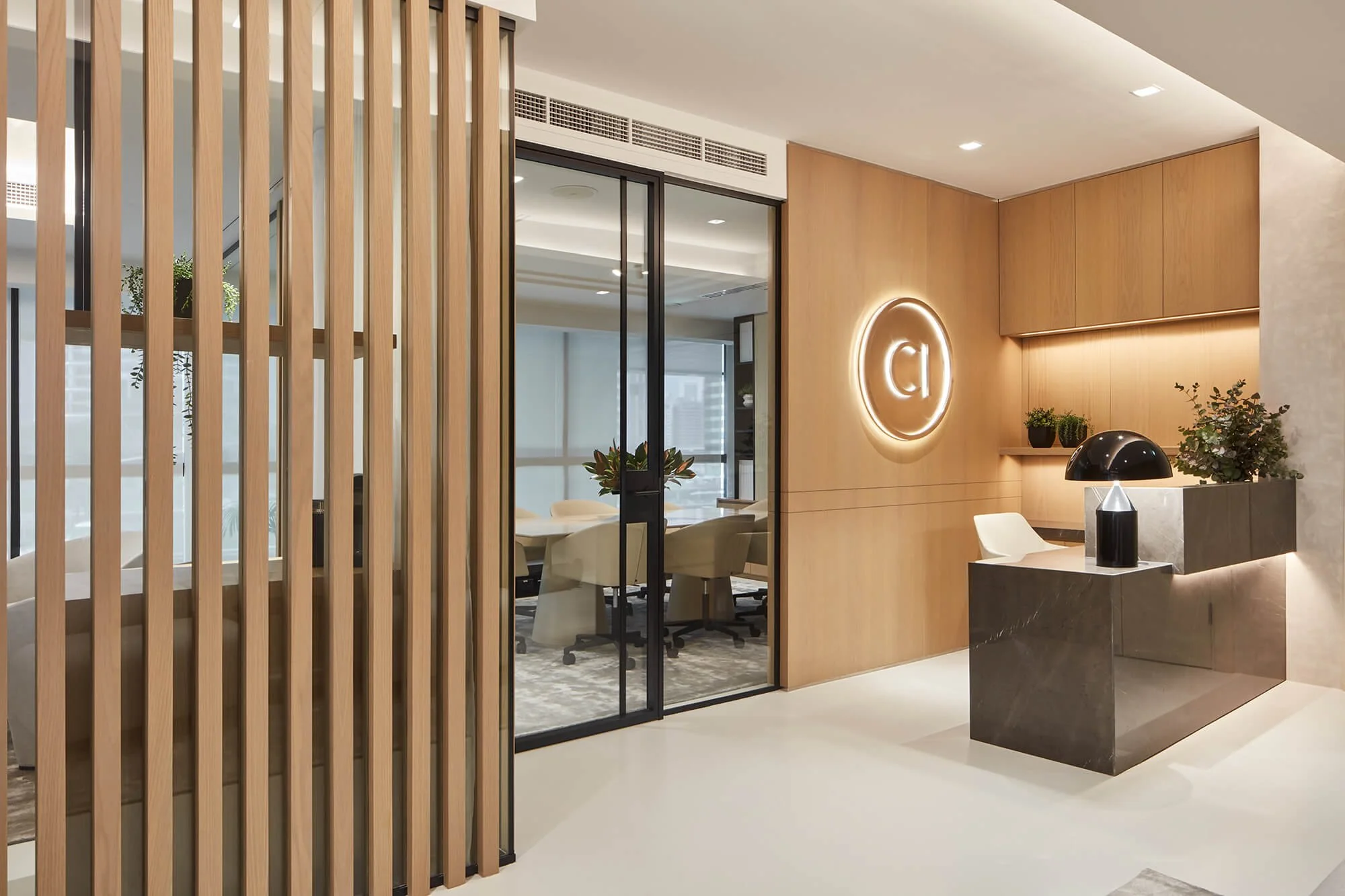 Contemporary office reception with residential-inspired interior design, featuring natural wood, marble and bespoke joinery by MIA Studio.