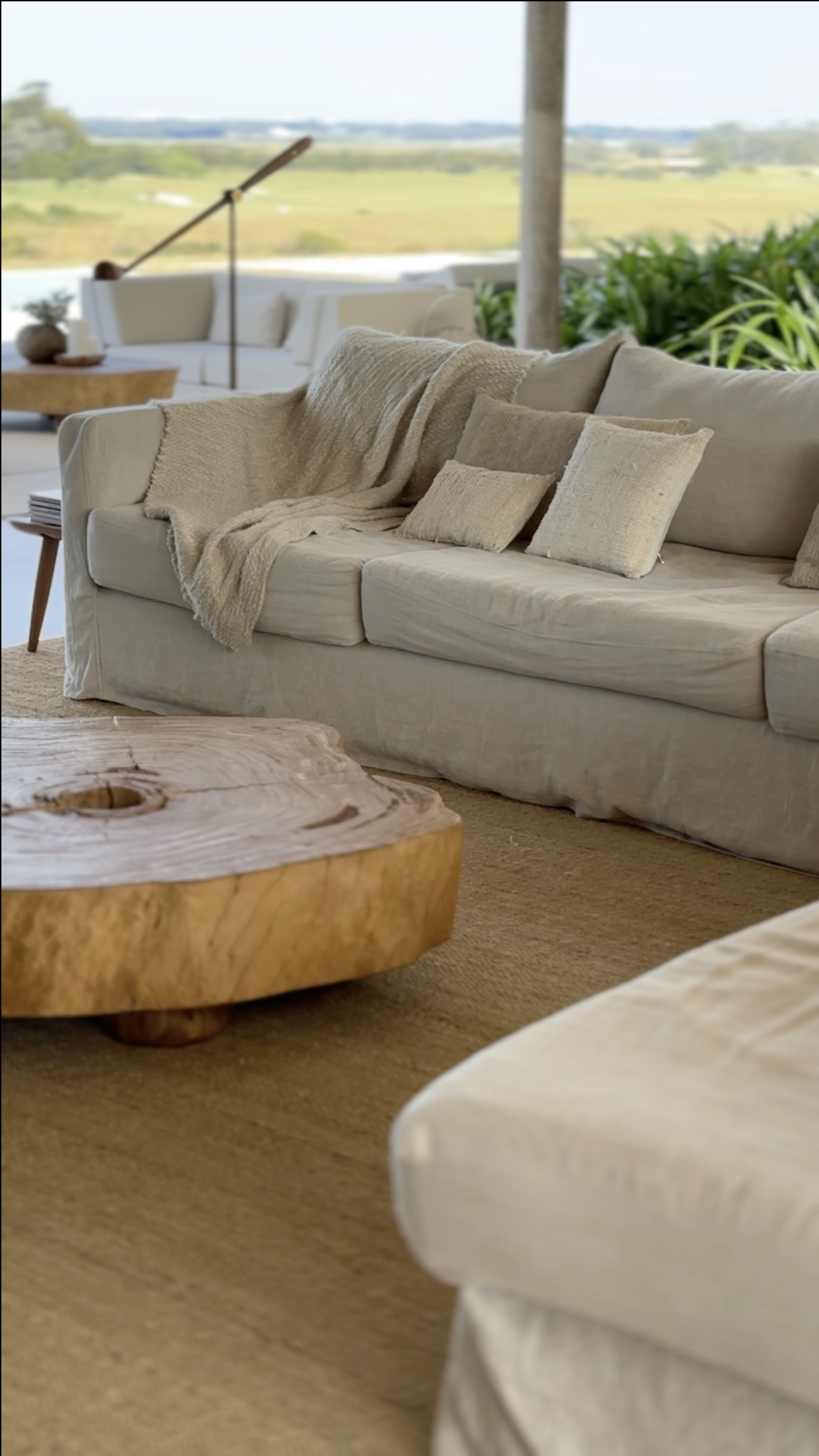 Contemporary living room with bespoke furnishings, natural materials and seamless indoor-outdoor connection by MIA Studio.