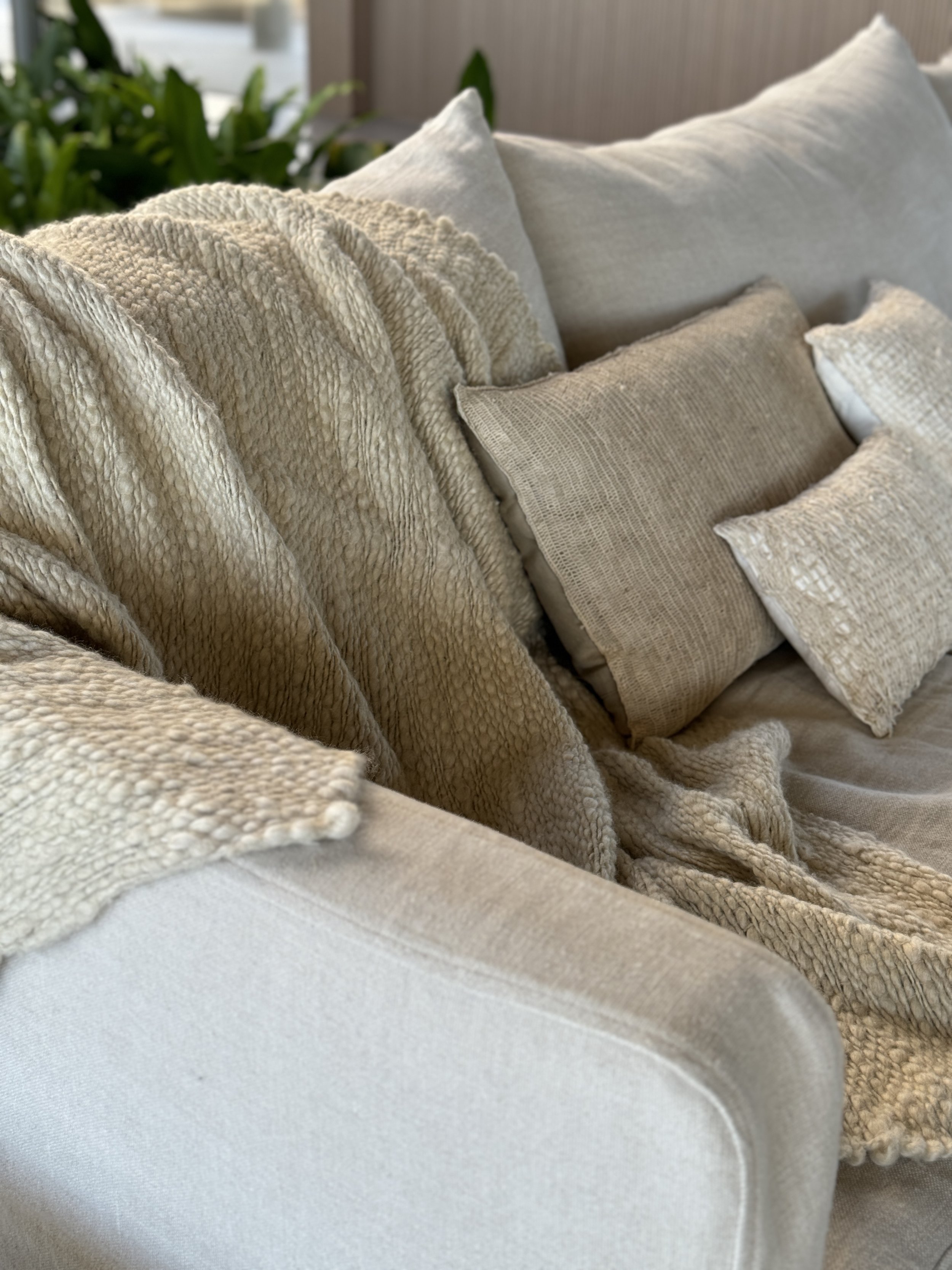 Luxury interior styling featuring textured linen cushions and layered neutral textiles by MIA Studio.