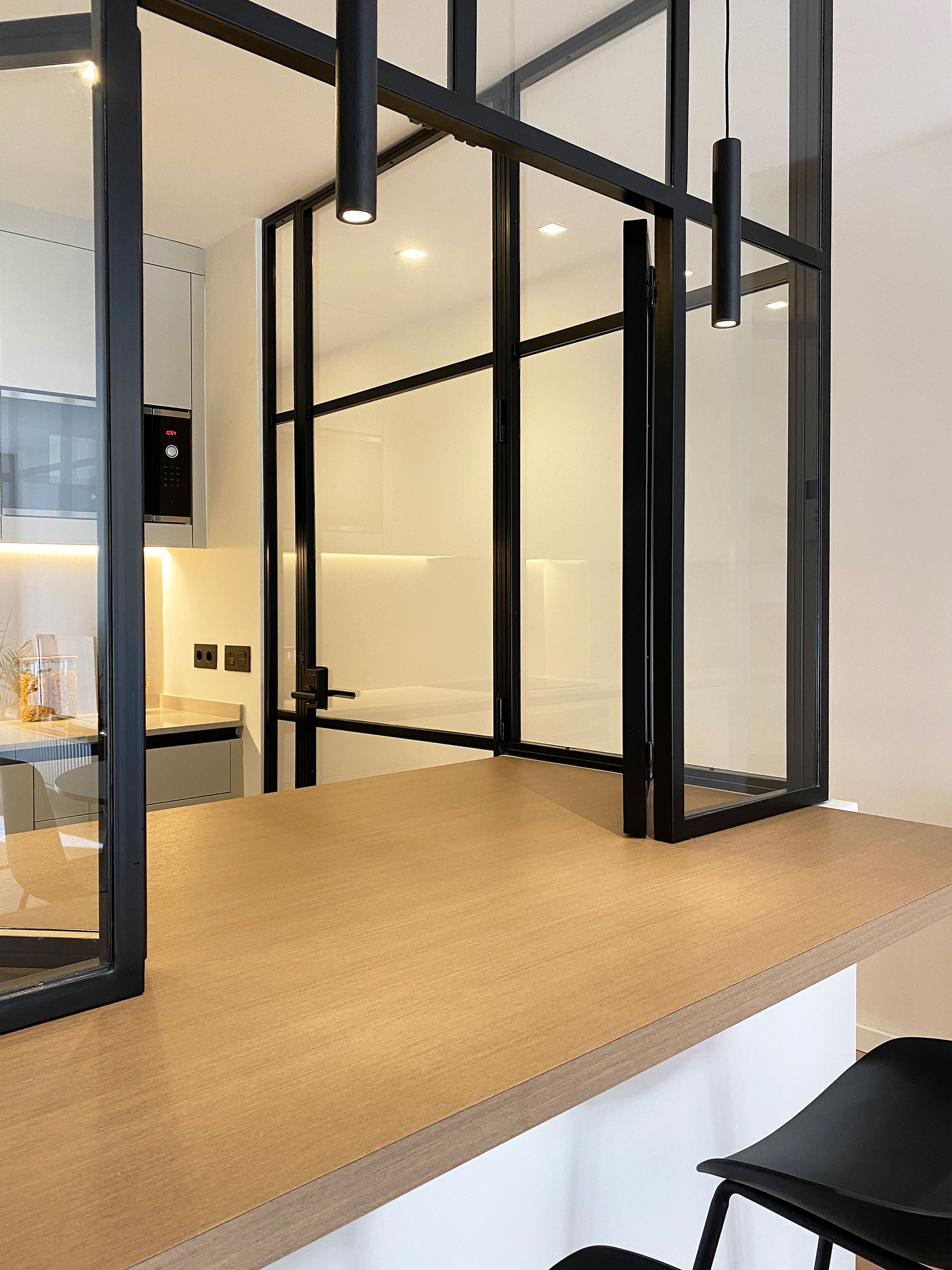 Contemporary apartment kitchen in Barcelona, Spain, featuring industrial minimalist interior design and bespoke cabinetry by MIA Studio.
