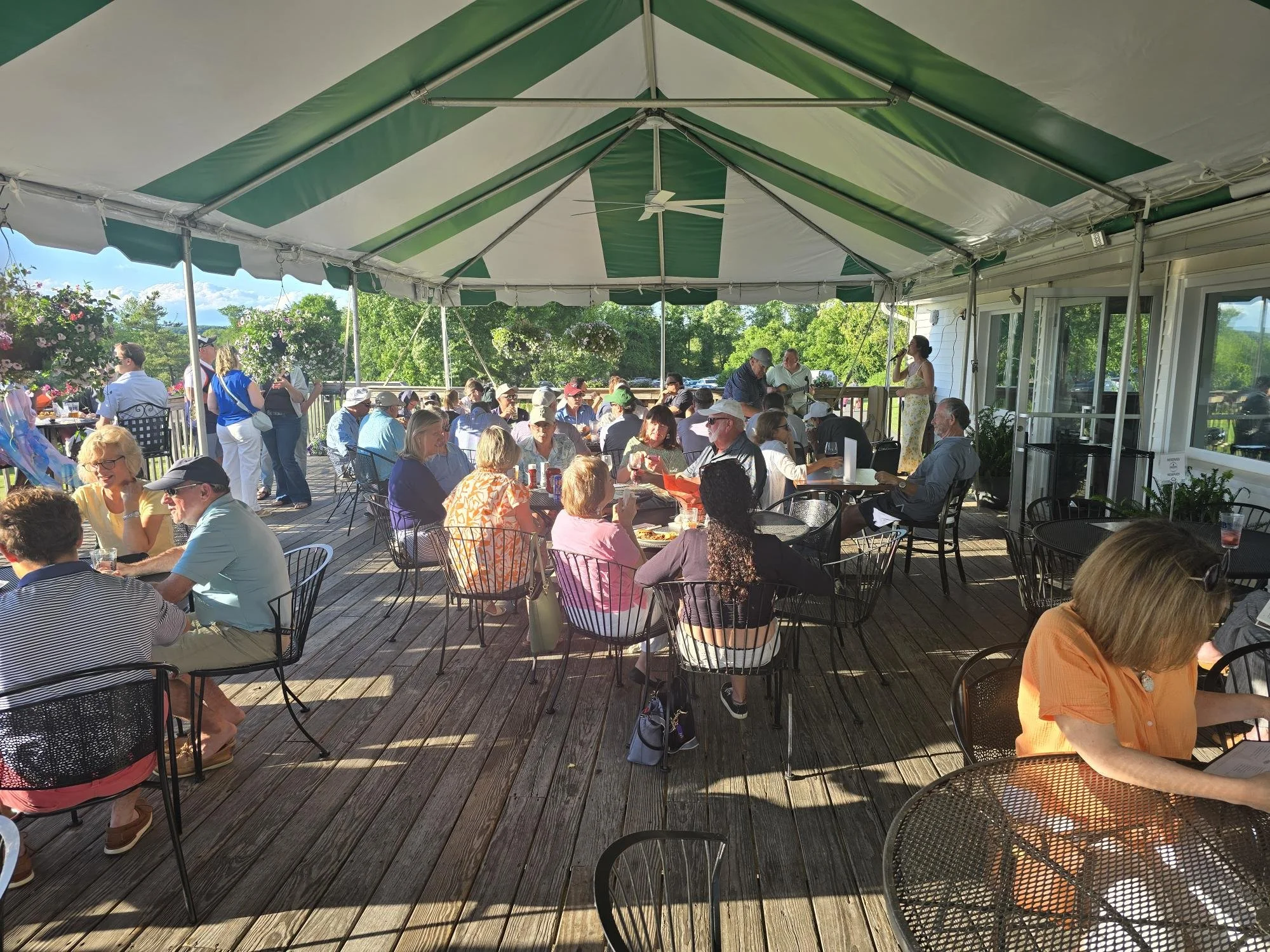 A group of people seated on a deck at Odeen’s in Ridgefield, enjoying live live music in a relaxed outdoor setting.